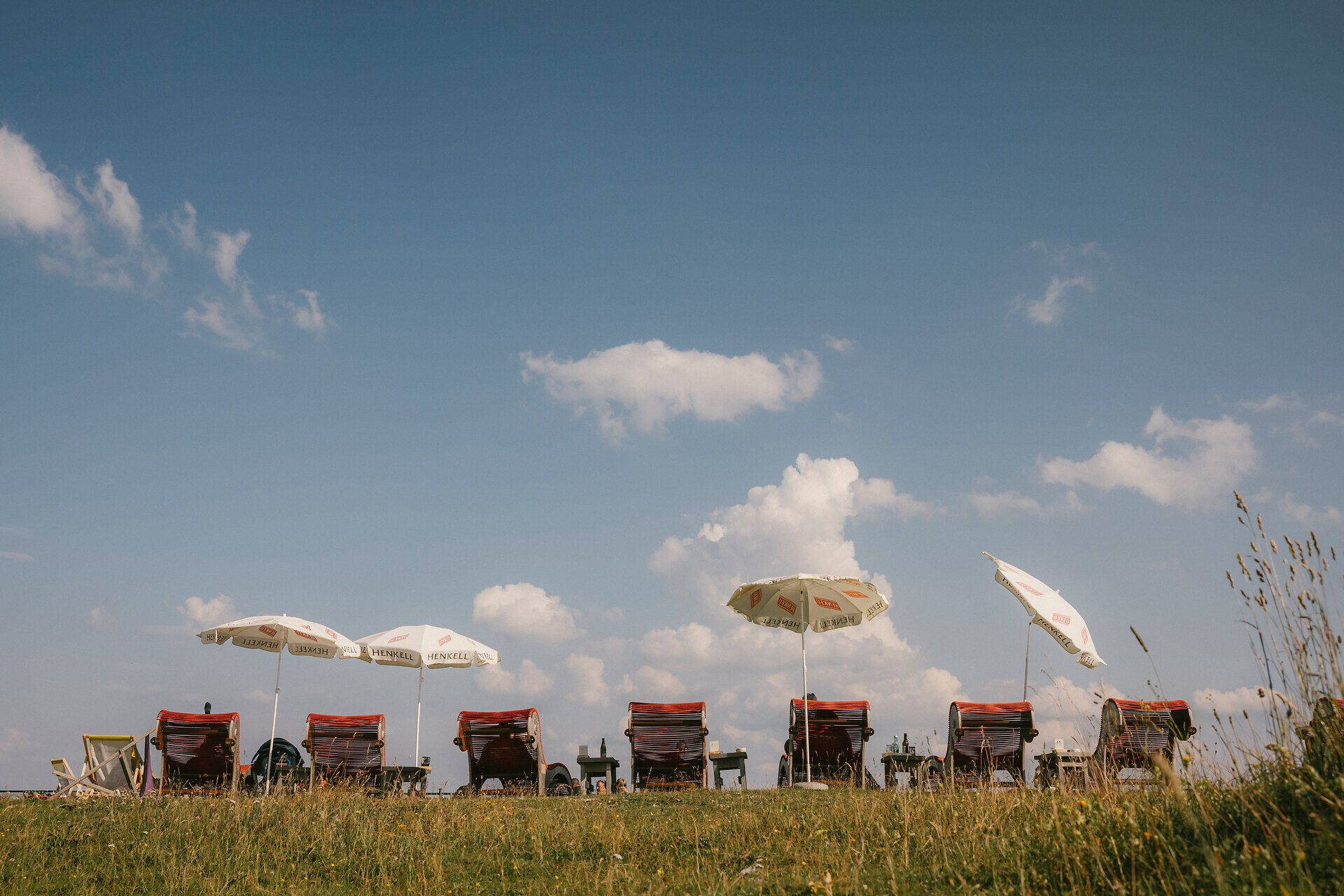 Deck chairs under umbrellas on the lawn near the Raxalm Mountain Inn