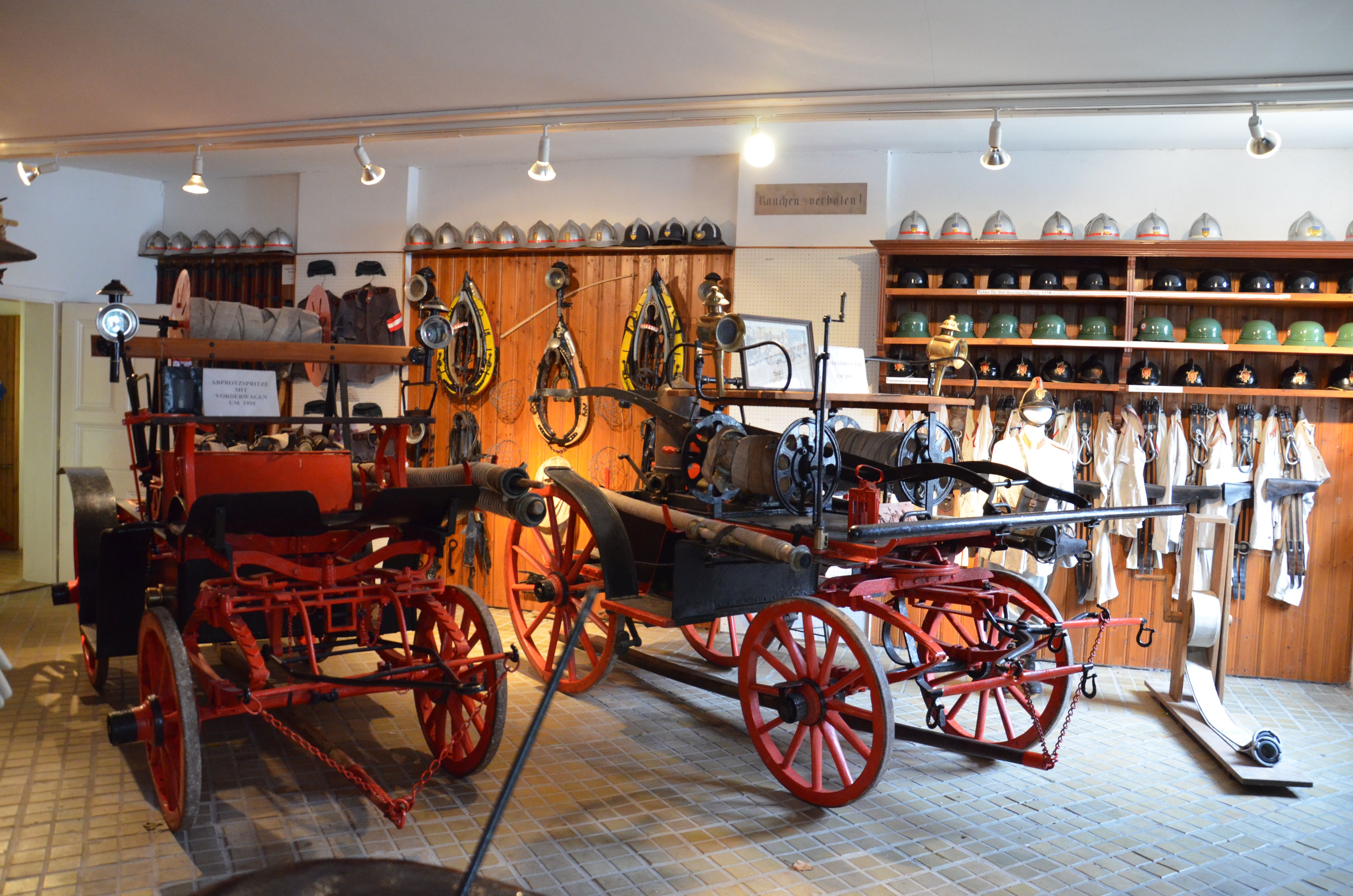 Interior view of the St. Leonhard am Forst Fire Brigade Museum with old firefighting equipment and helmets.