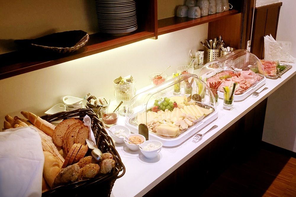 Breakfast buffet with bread, cold cuts and cheese.
