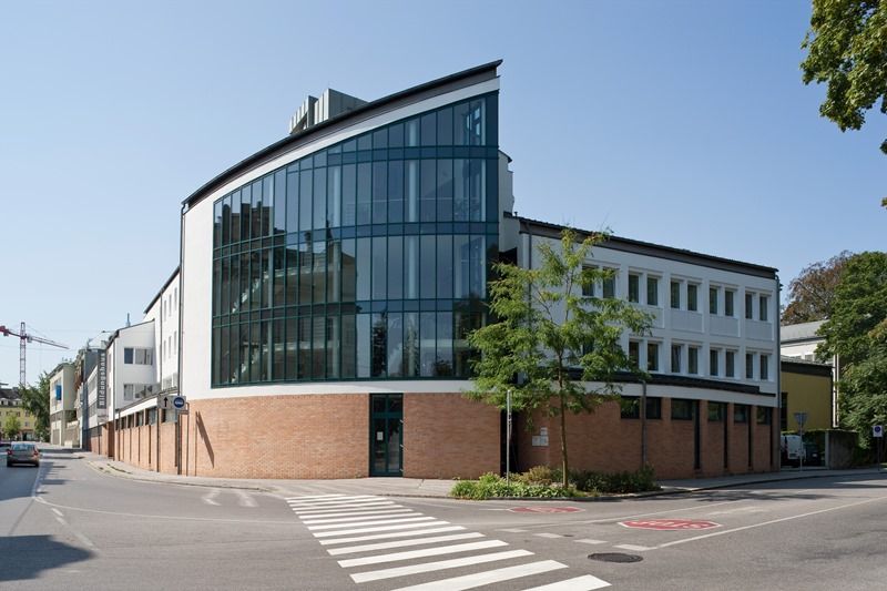 Modern building with glass façade and brickwork on a street corner.