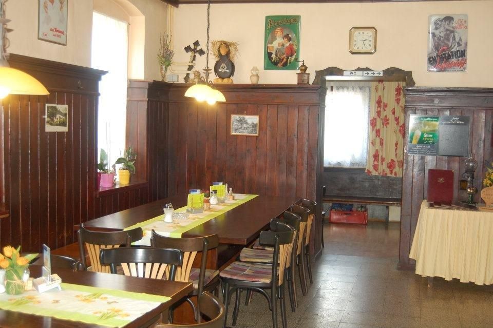 Cozy guest room with wood paneling, table with chairs, decorative posters and a clock on the wall.