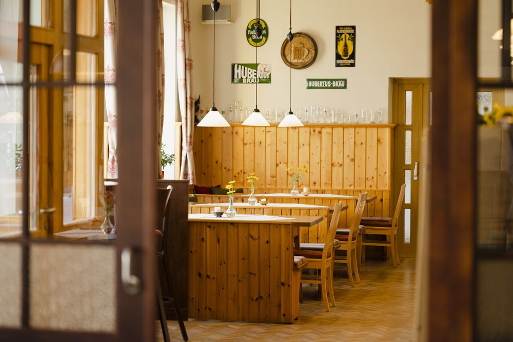 Interior view of a traditional Austrian inn with wooden furniture and decorations on the walls.