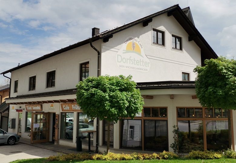 Exterior view of the Dorfstetter bakery with trees in front.