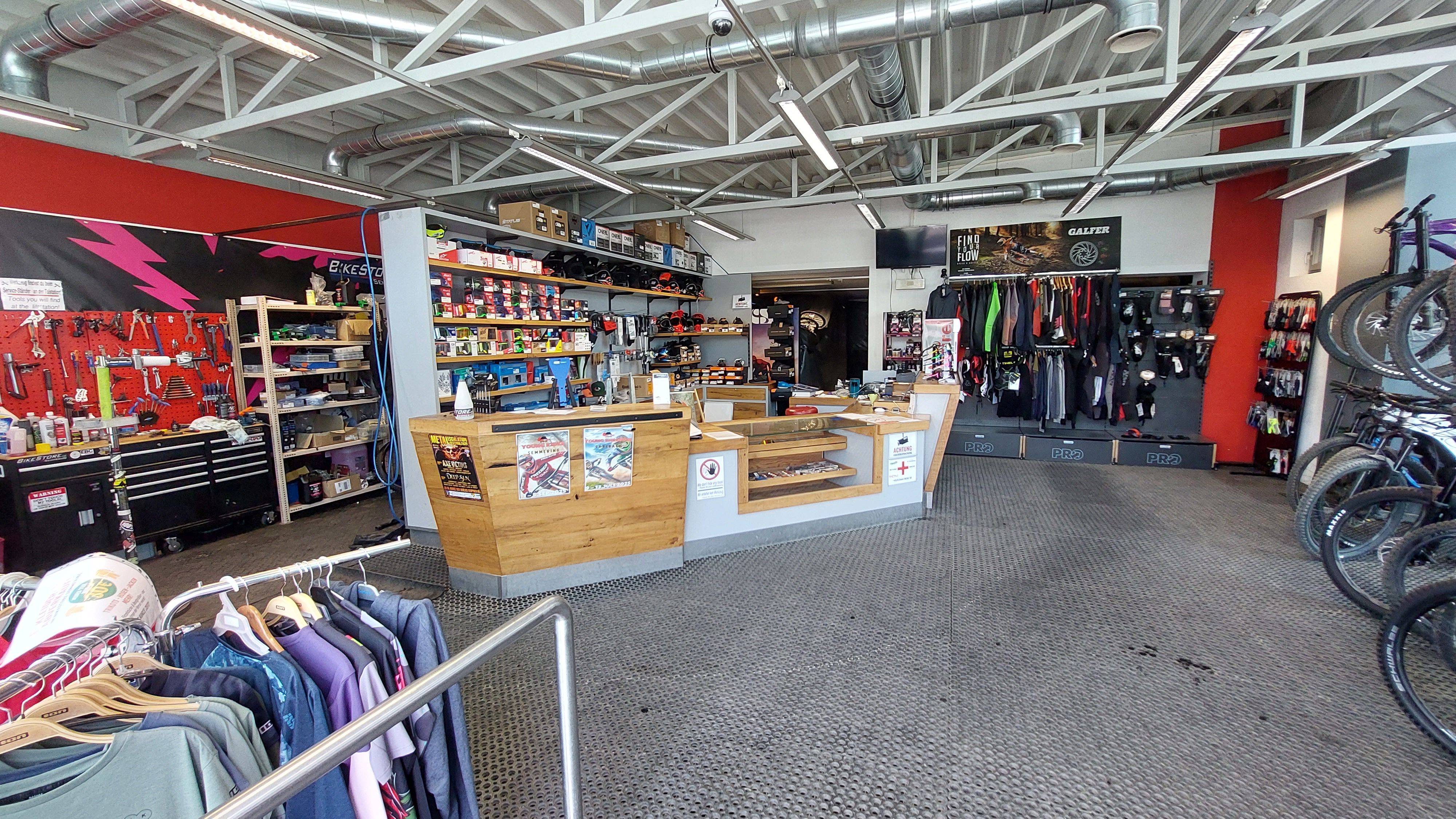 Interior view of a bicycle store with workshop area, sales counter and bicycle accessories.