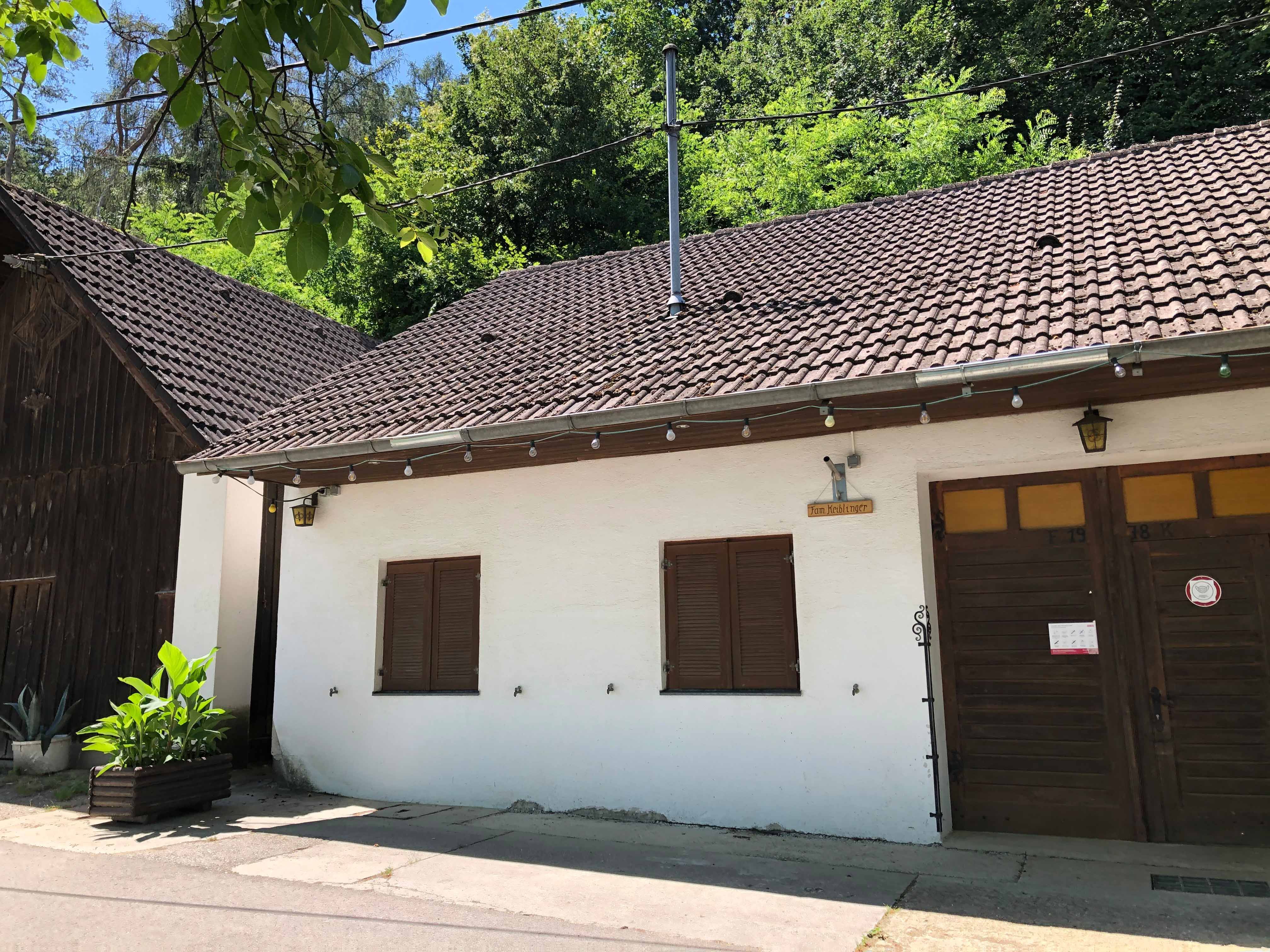 Exterior view of a wine tavern with a white façade and wooden door.