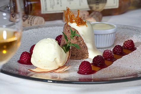 Dessert plate with chocolate cake, vanilla ice cream, raspberries and sauce.