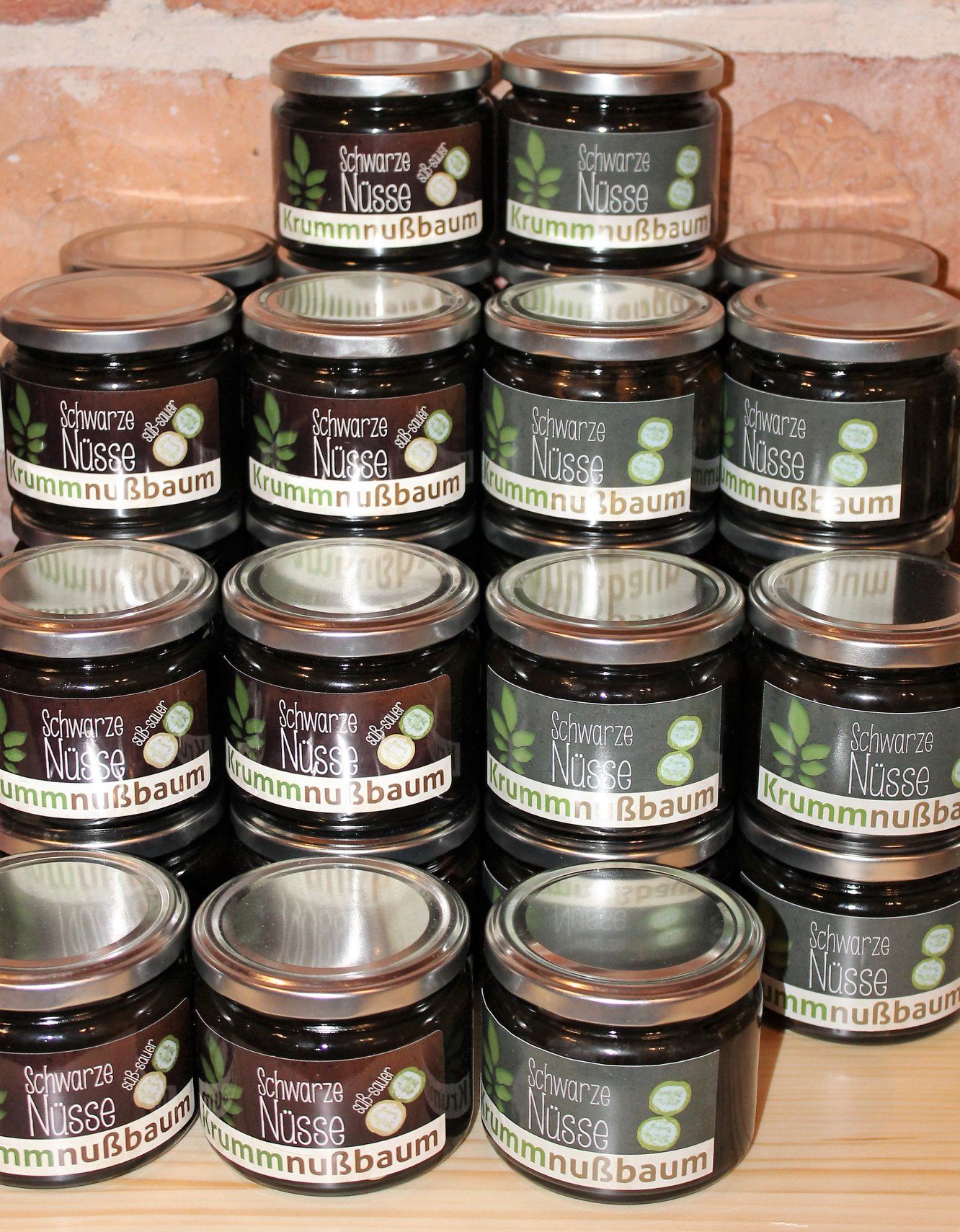Several jars labeled 'Schwarze Nüsse Krummnußbaum' stacked on a table.