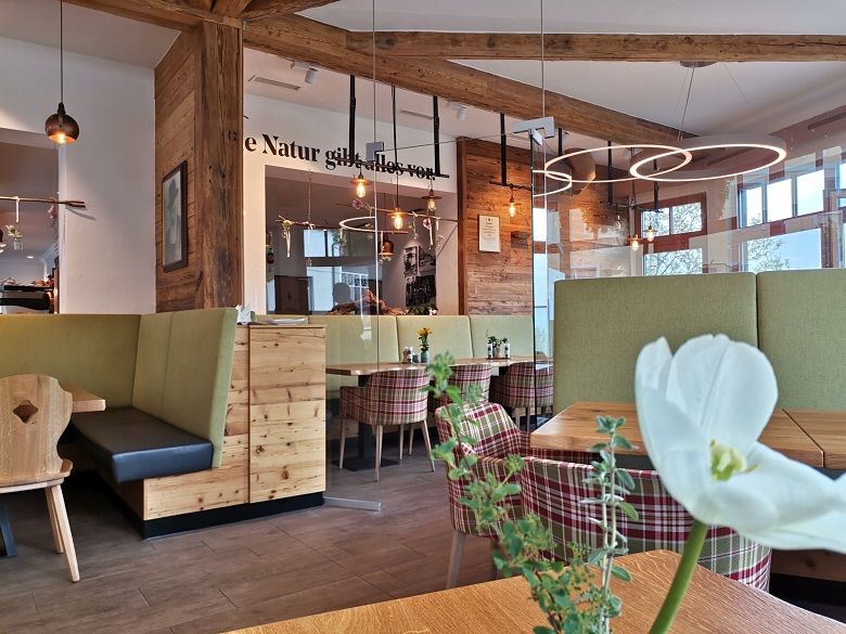 Interior view of a cozy bakery with wooden furniture and modern lighting.
