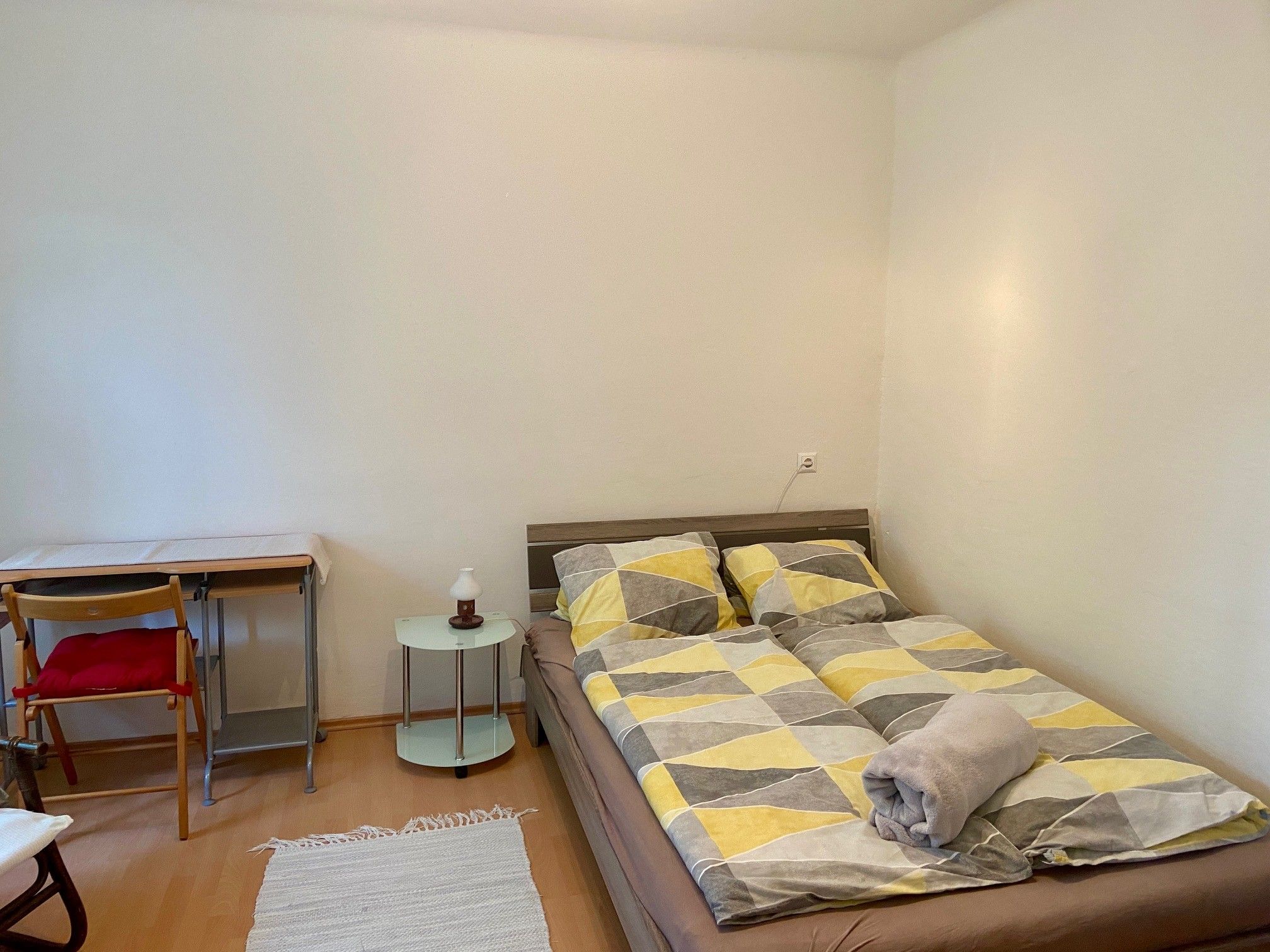 Bedroom with double bed, desk and chair.