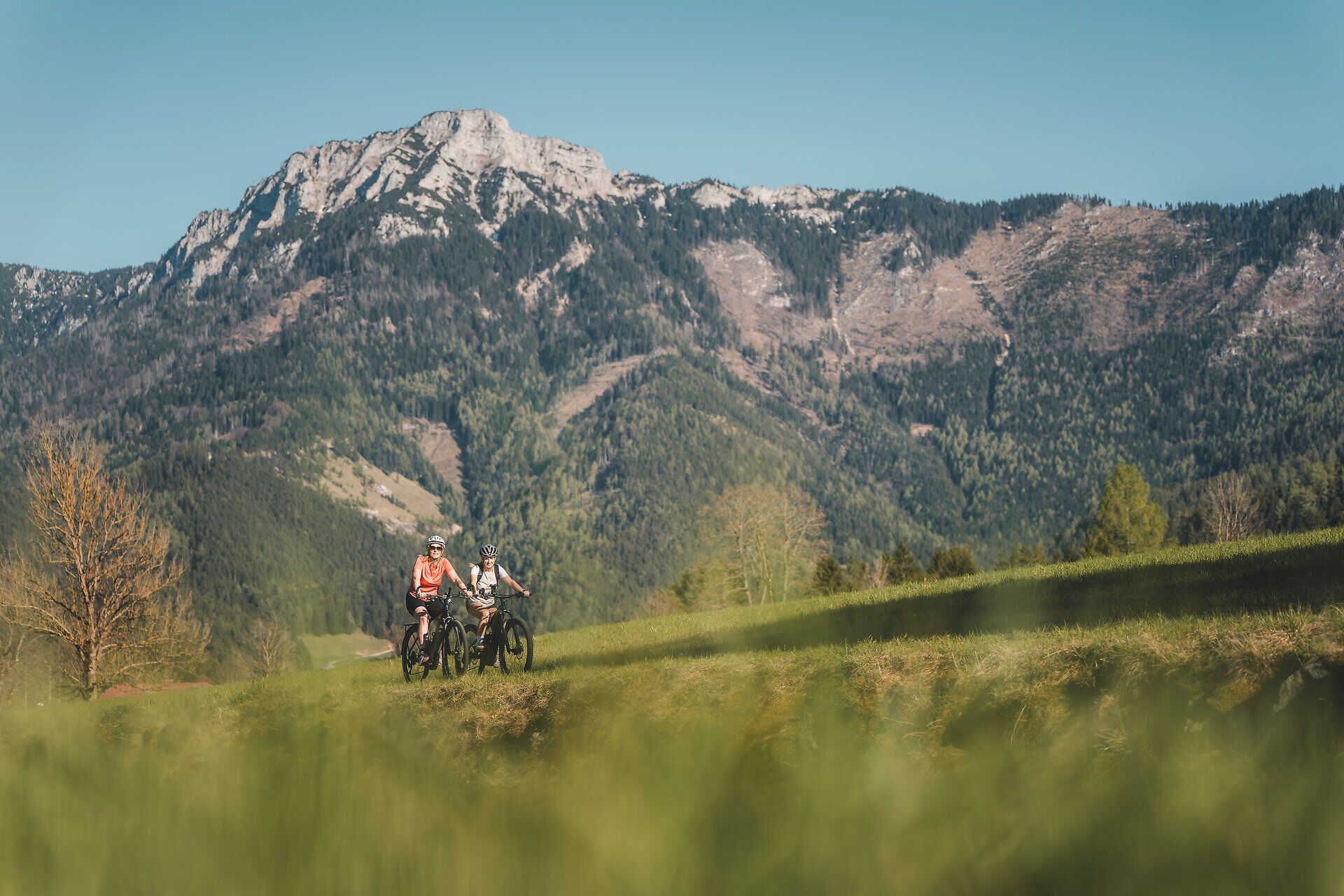 Two cyclists on the Traisental cycle route, mountain panorama in the background.