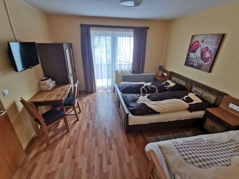 Comfortable bedroom with double bed, table, chairs and balcony access.
