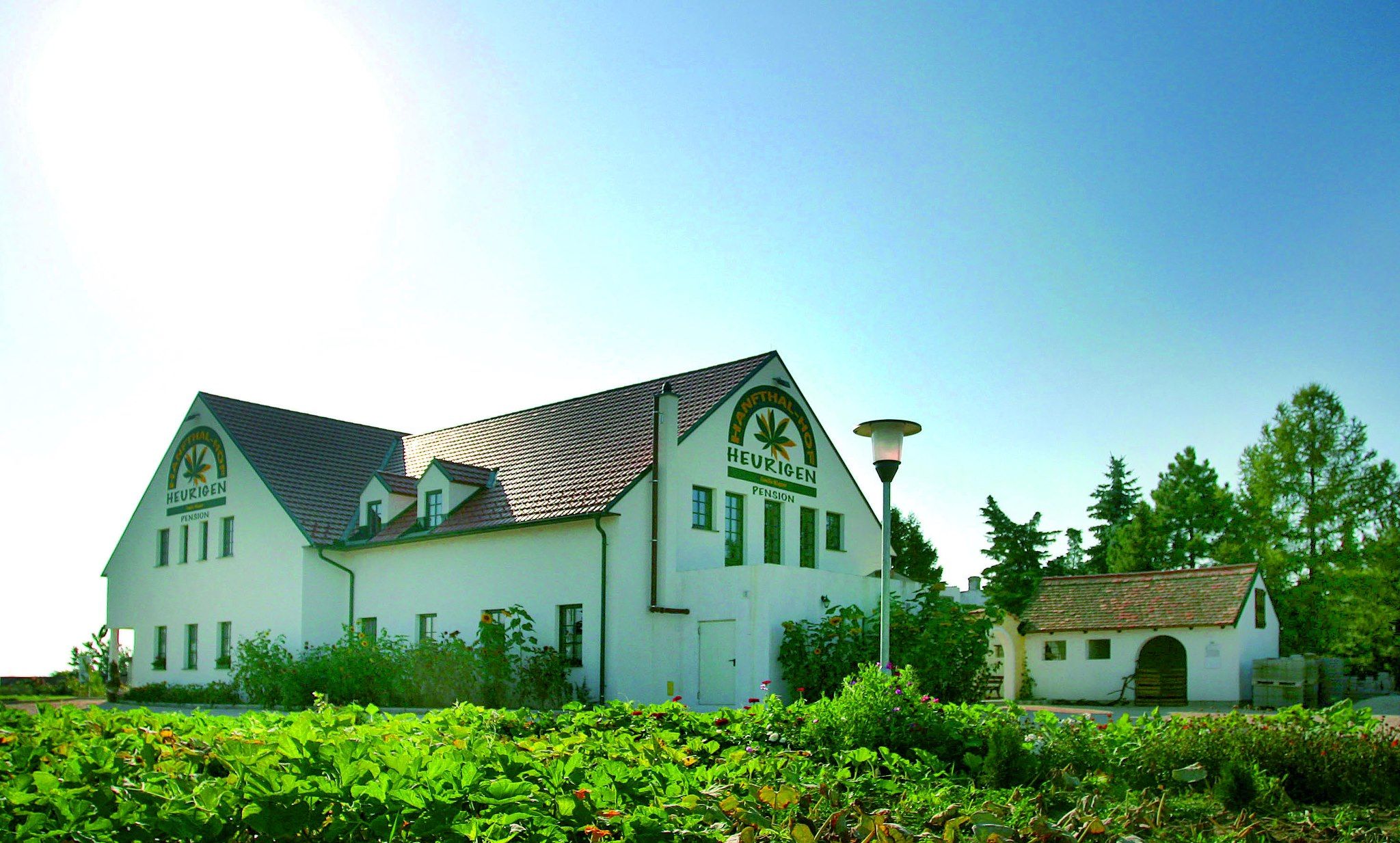 Exterior view of a building with the inscription 'Hanftalhof Heurigen Pension'.
