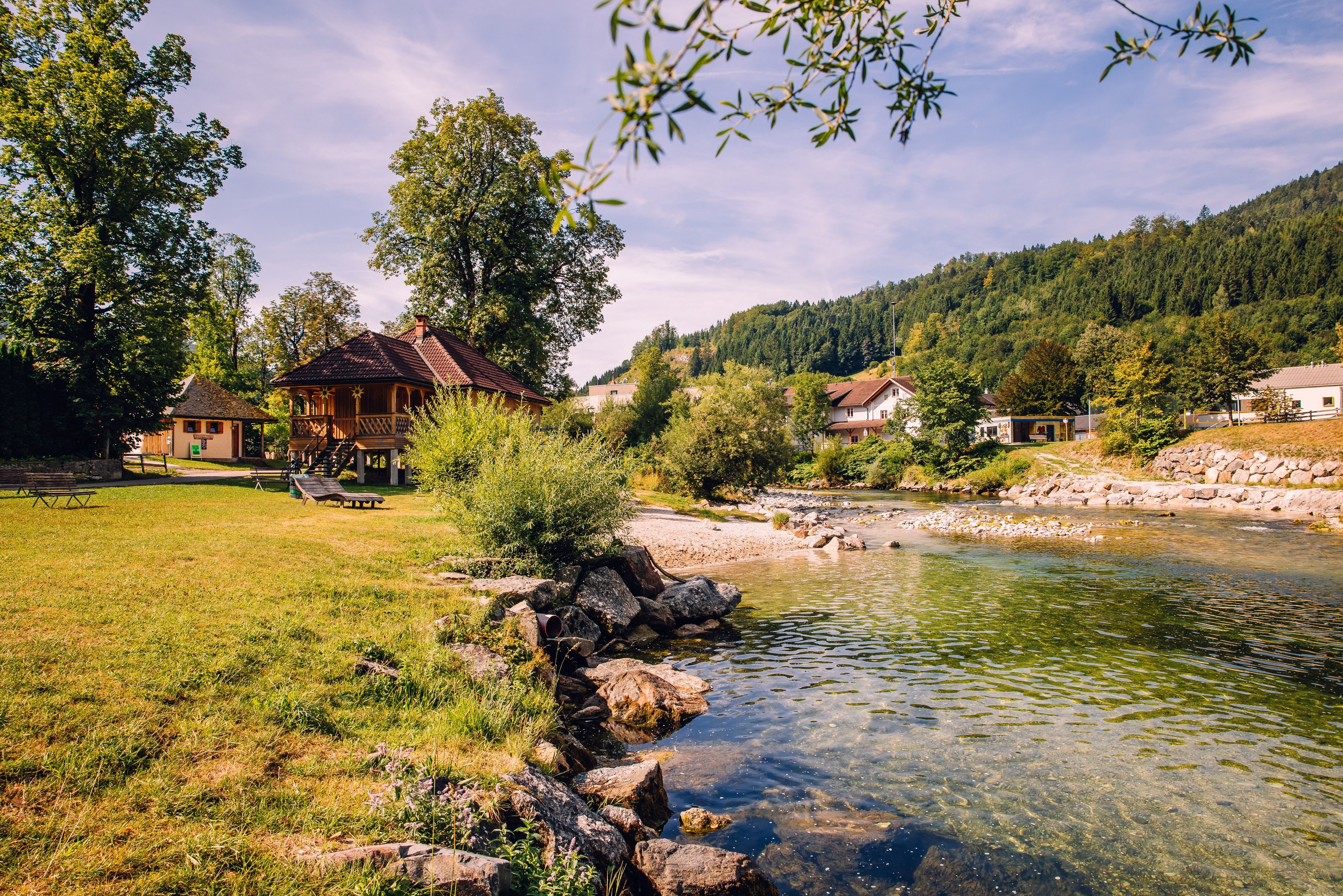 A river swimming spot on the Ybbs in Göstling, with meadows, trees, and a wooden house set against wooded hills.