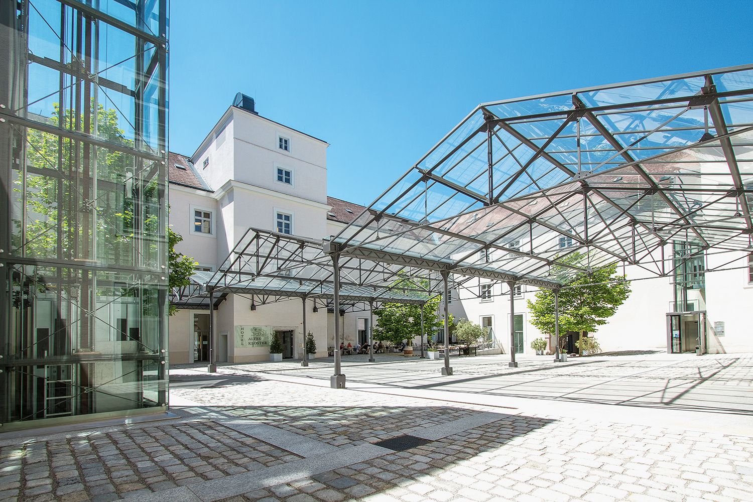 Inner courtyard of the Hotel Altes Kloster with glass roof and modern design.