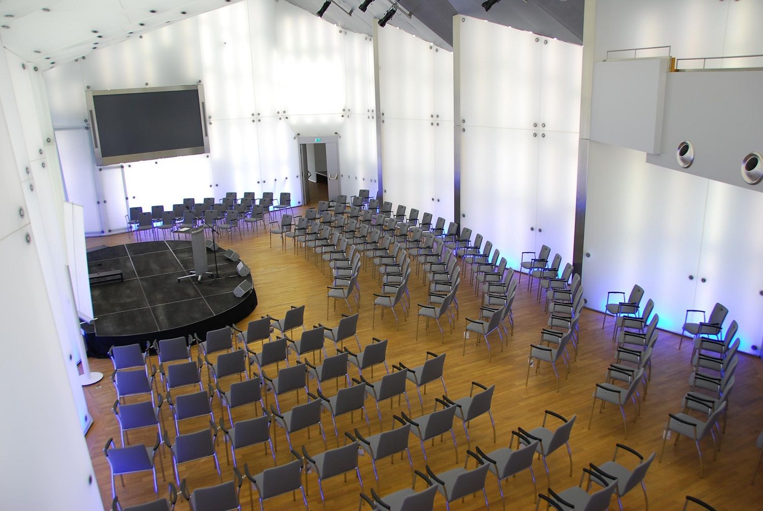 Modern conference hall with rows of chairs and stage in Schloss Rothschild, Kristallsaal.