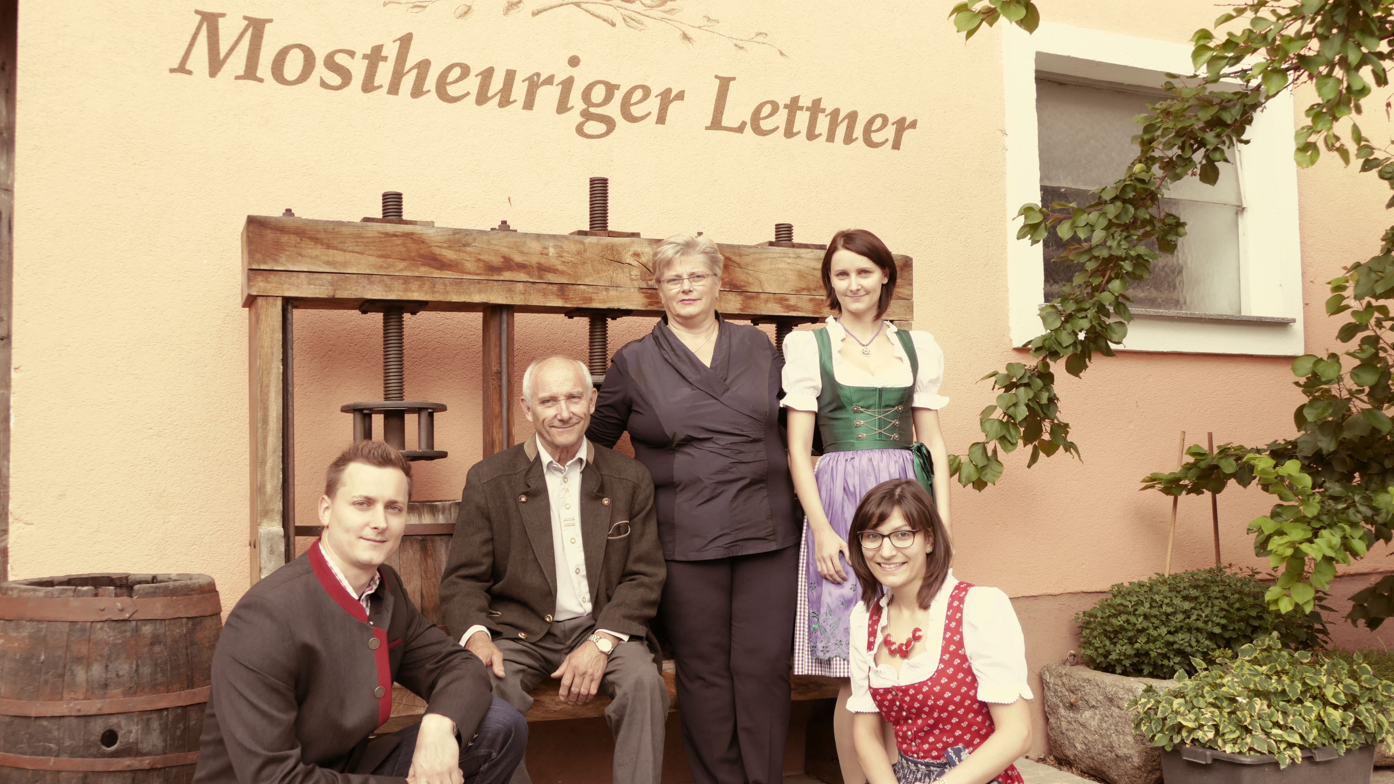 Group of five people in front of the building of the Tavern Lettner.