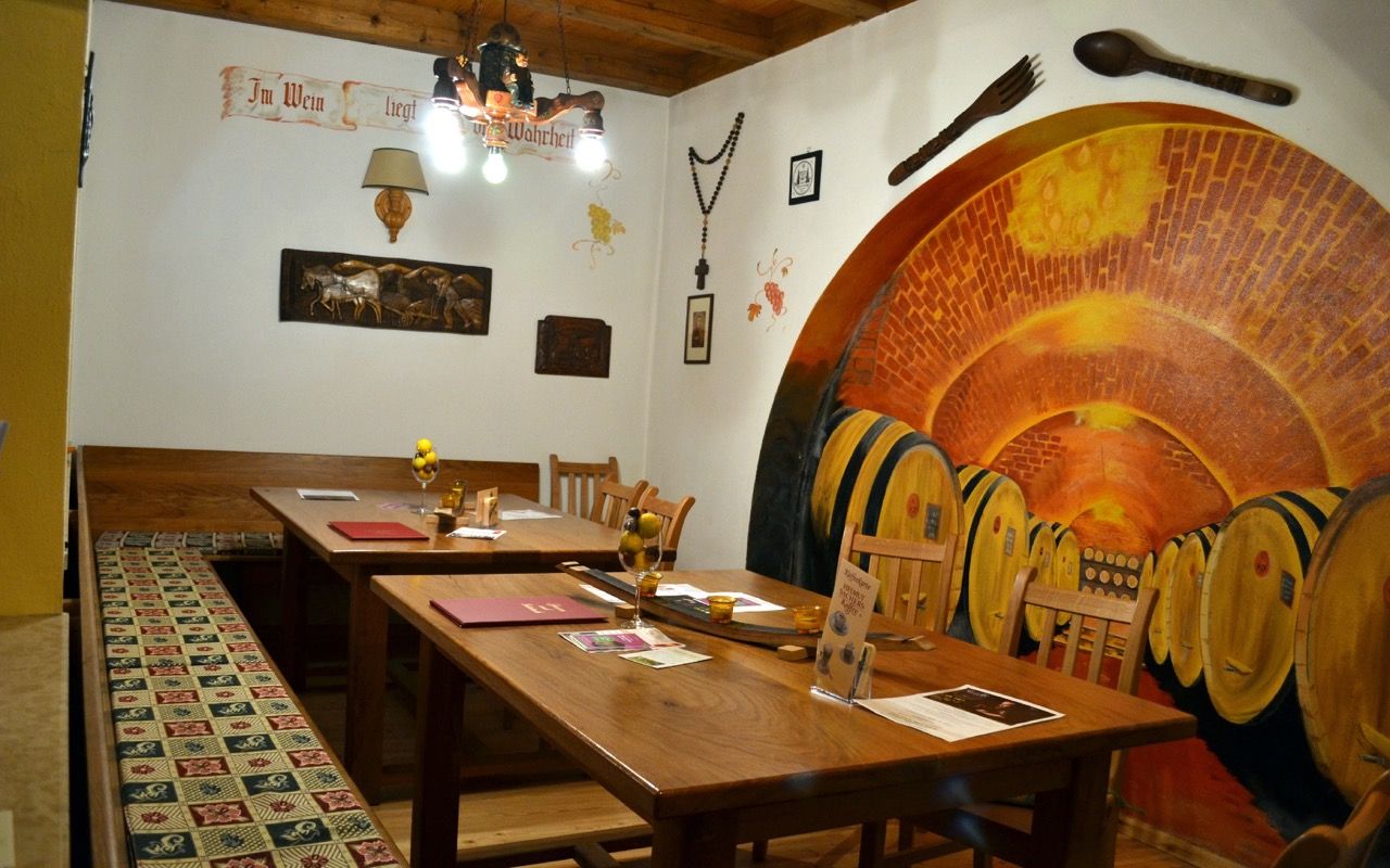 Cozy Lössiade parlor with wooden tables, warm lighting and traditional furnishings.