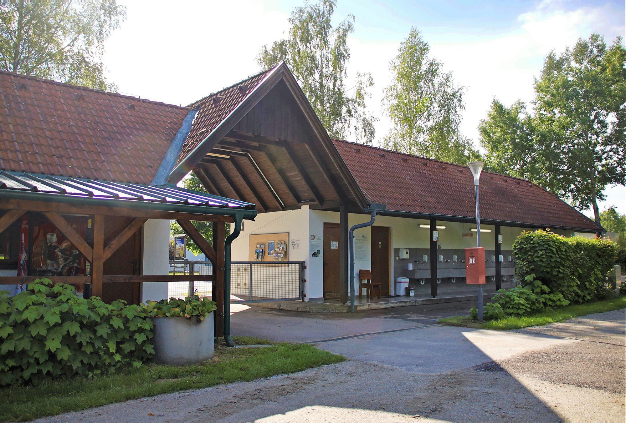 Exterior view of a building with red tiled roofs and outdoor washbasins.
