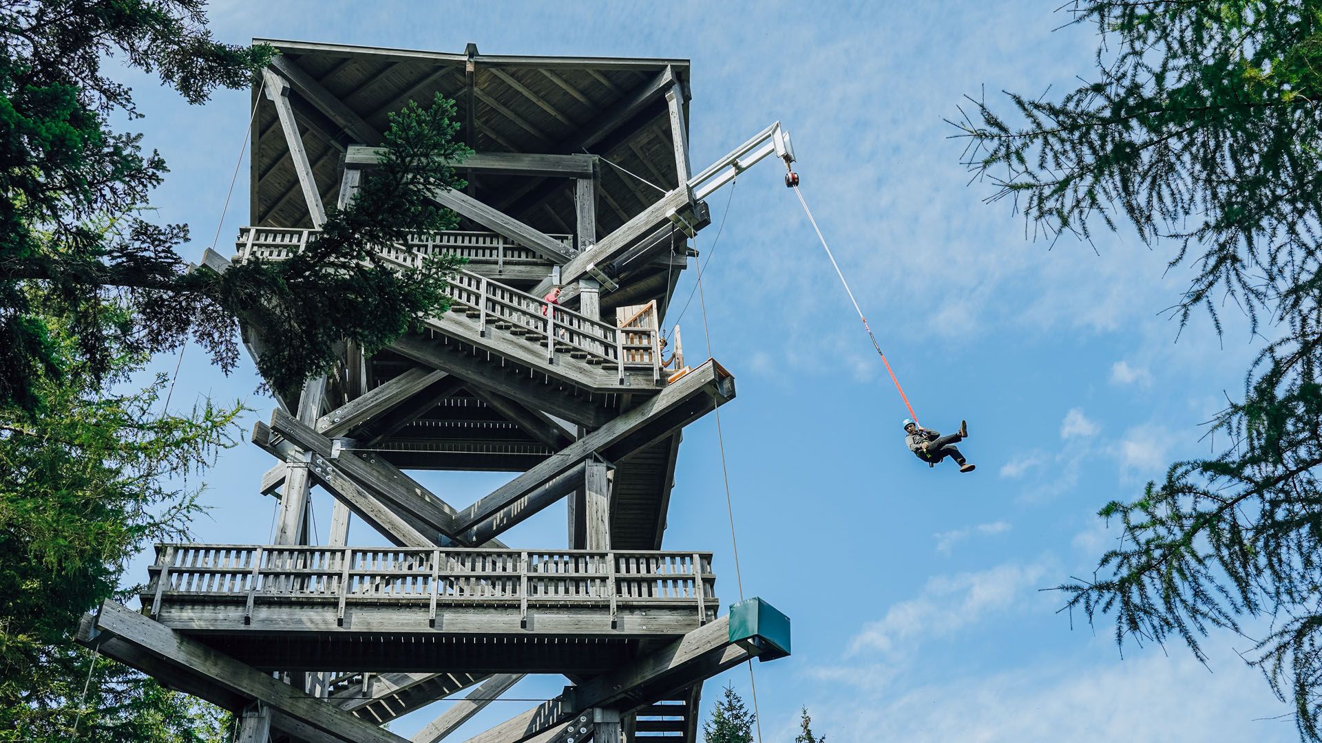 Person jumping with a rope from a lookout point.