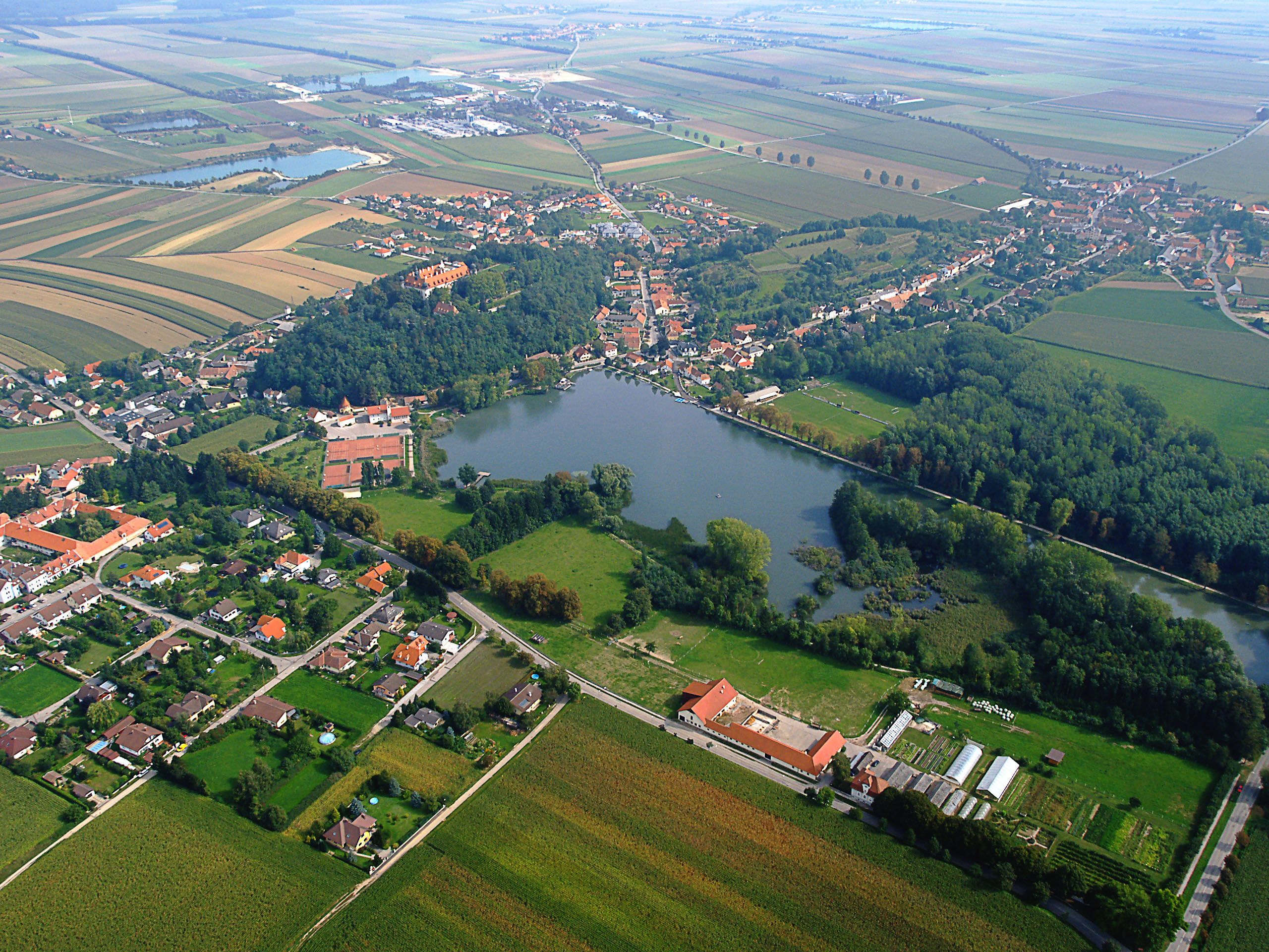 Aerial view of Sitzenberg-Reidling with castle, lake and surrounding fields.