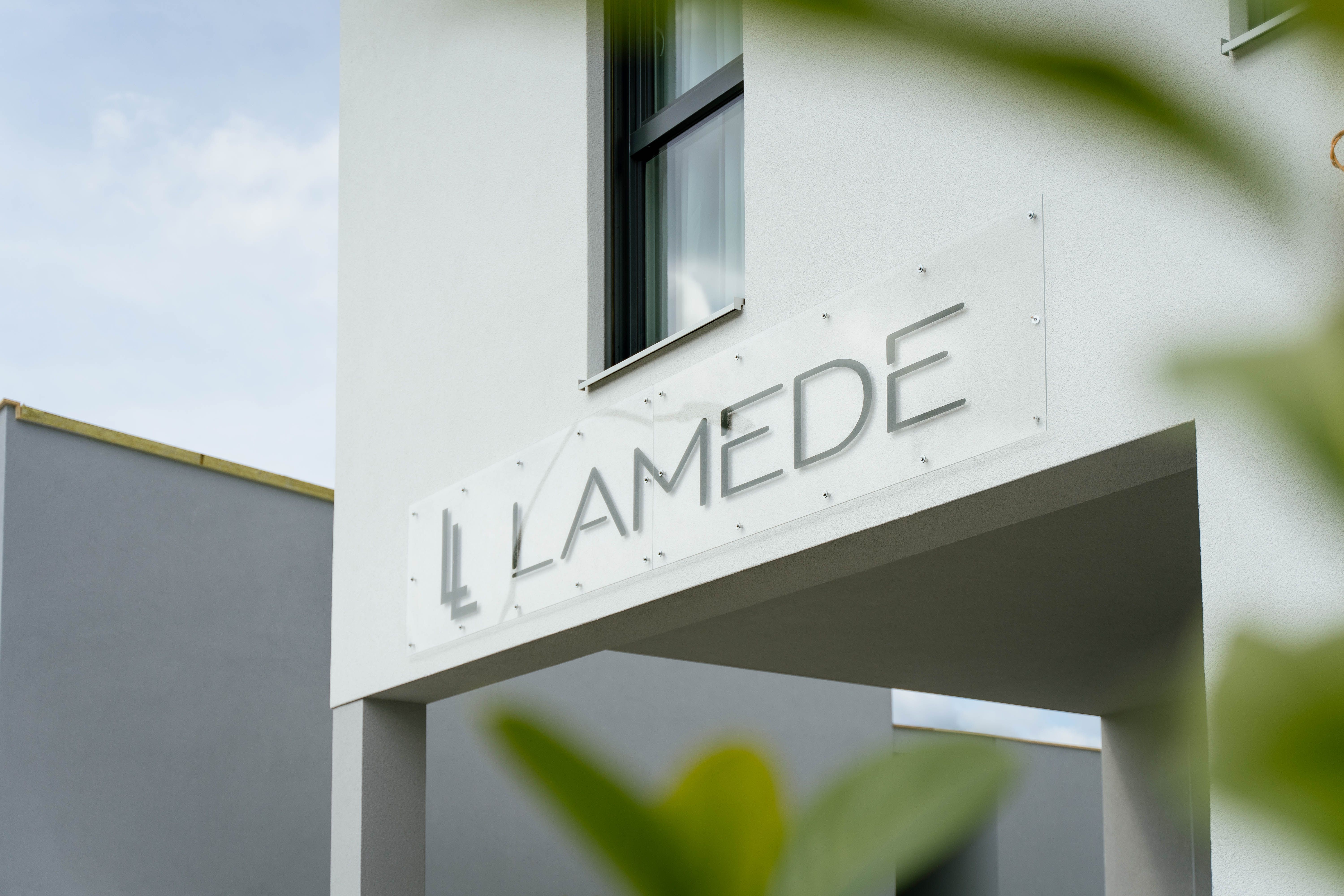 Modern building exterior with the lettering 'LAMEDE' on a sign.