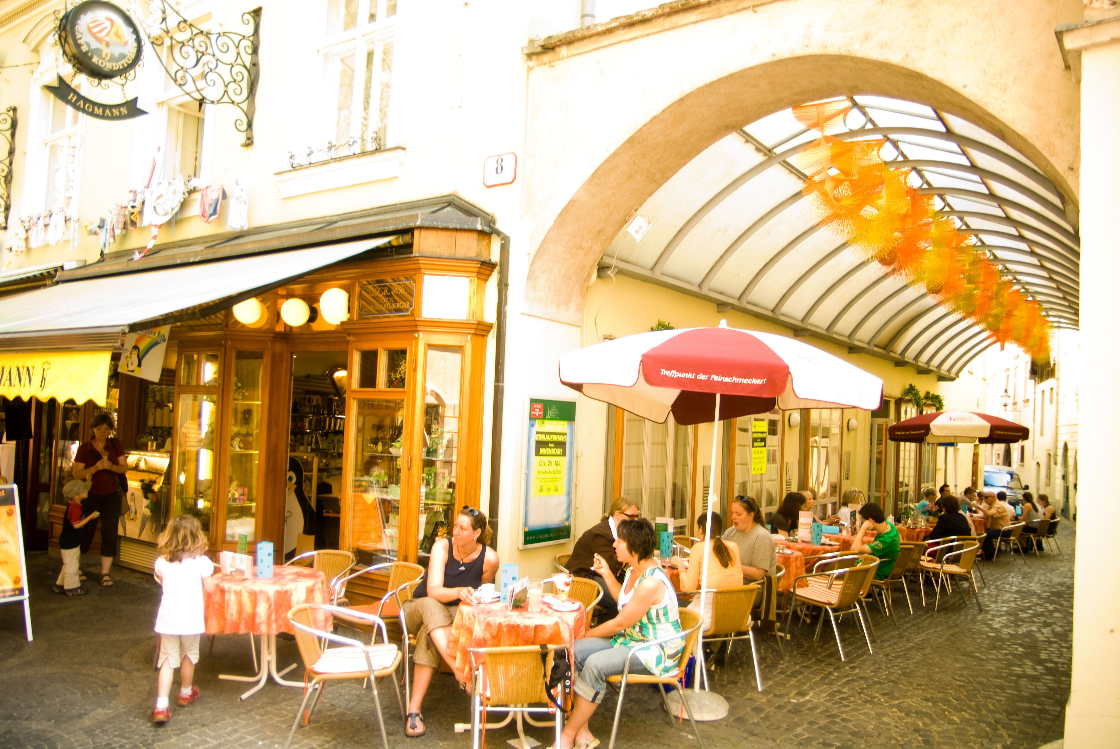 Outdoor area of the patisserie with tables and parasols in the pedestrian zone of Krems.