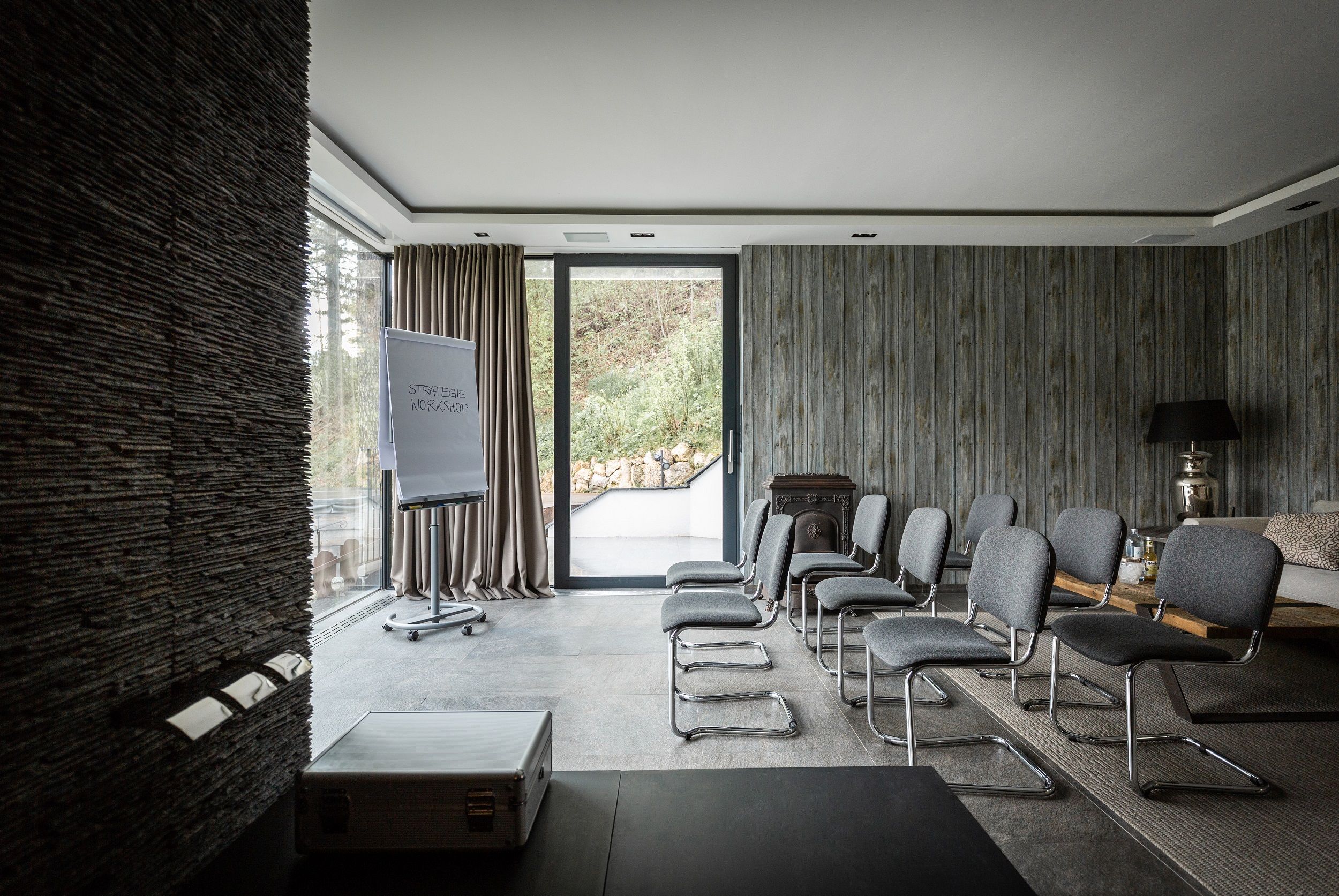 Modern conference room with gray chairs, flipchart and large windows.