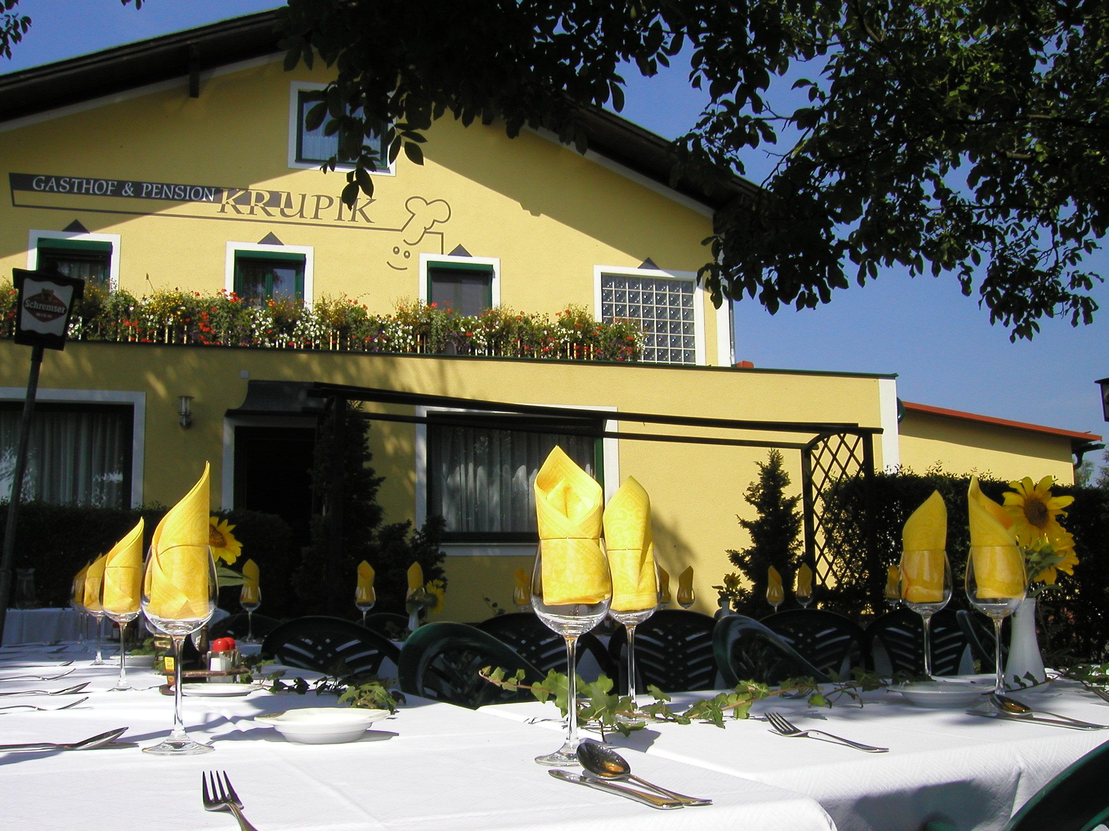 Exterior view of the Krupik inn with a laid table in the foreground.