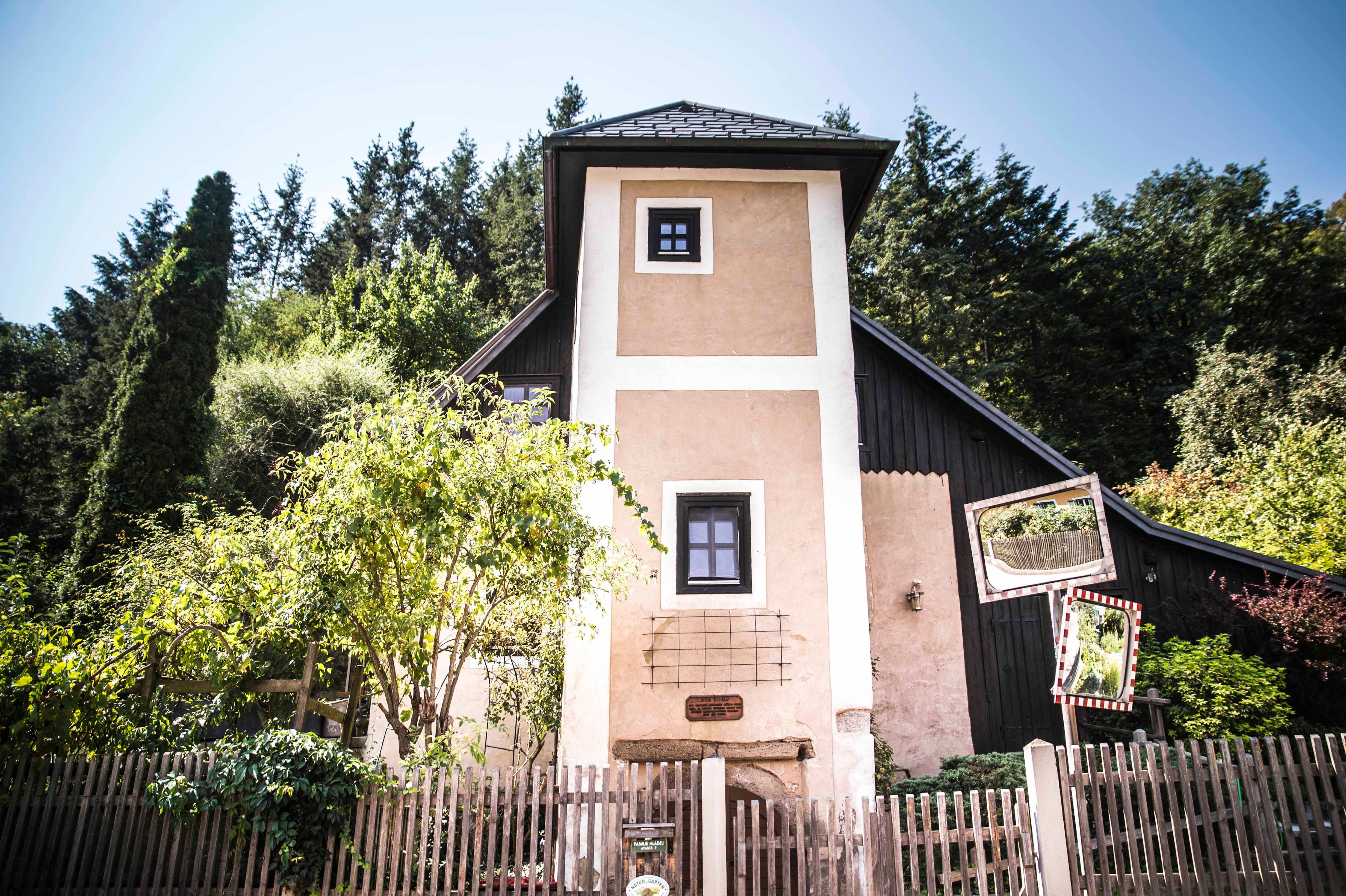A small tower with a wooden fence and trees in the background.