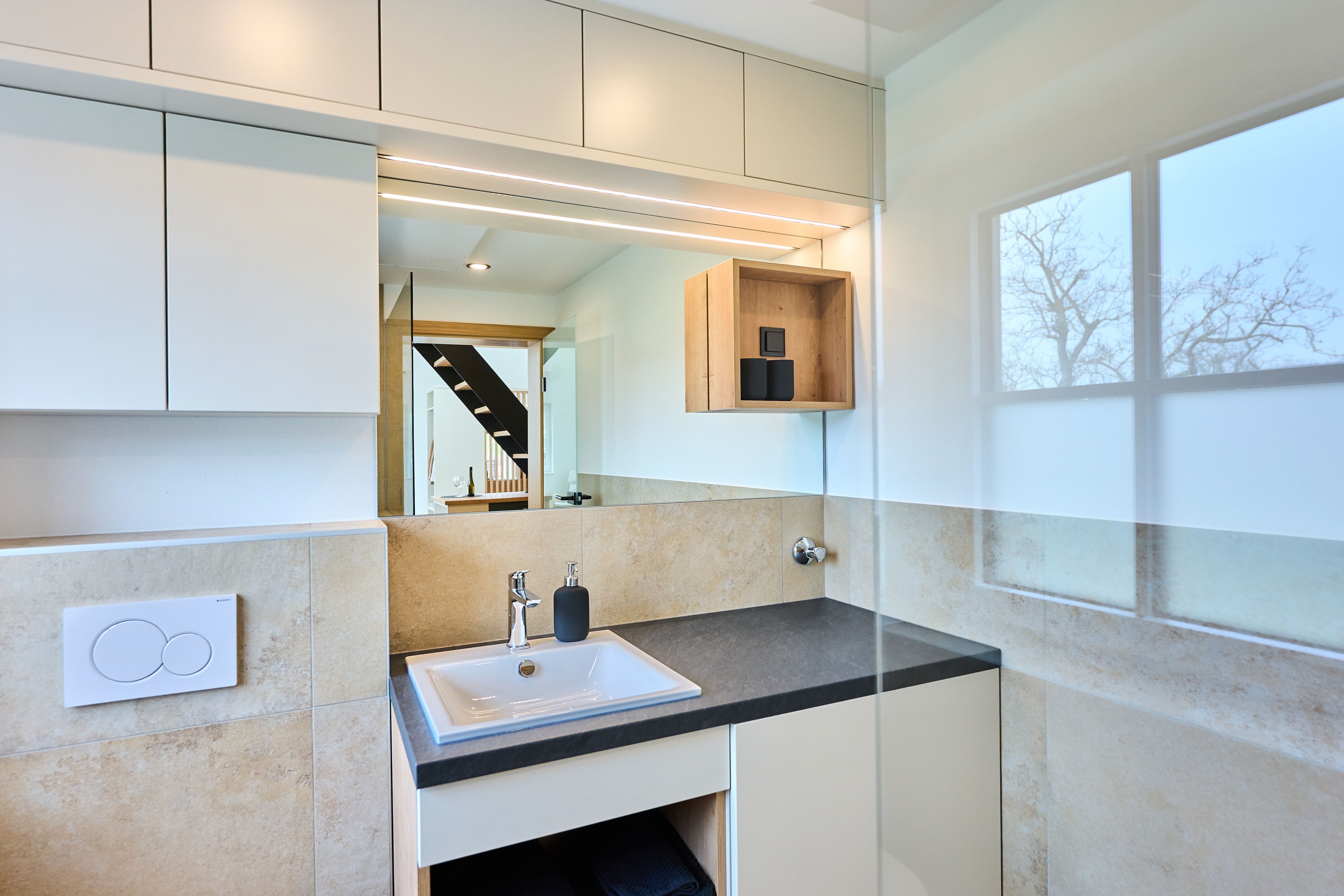 Modern bathroom with washbasin, mirror and window.