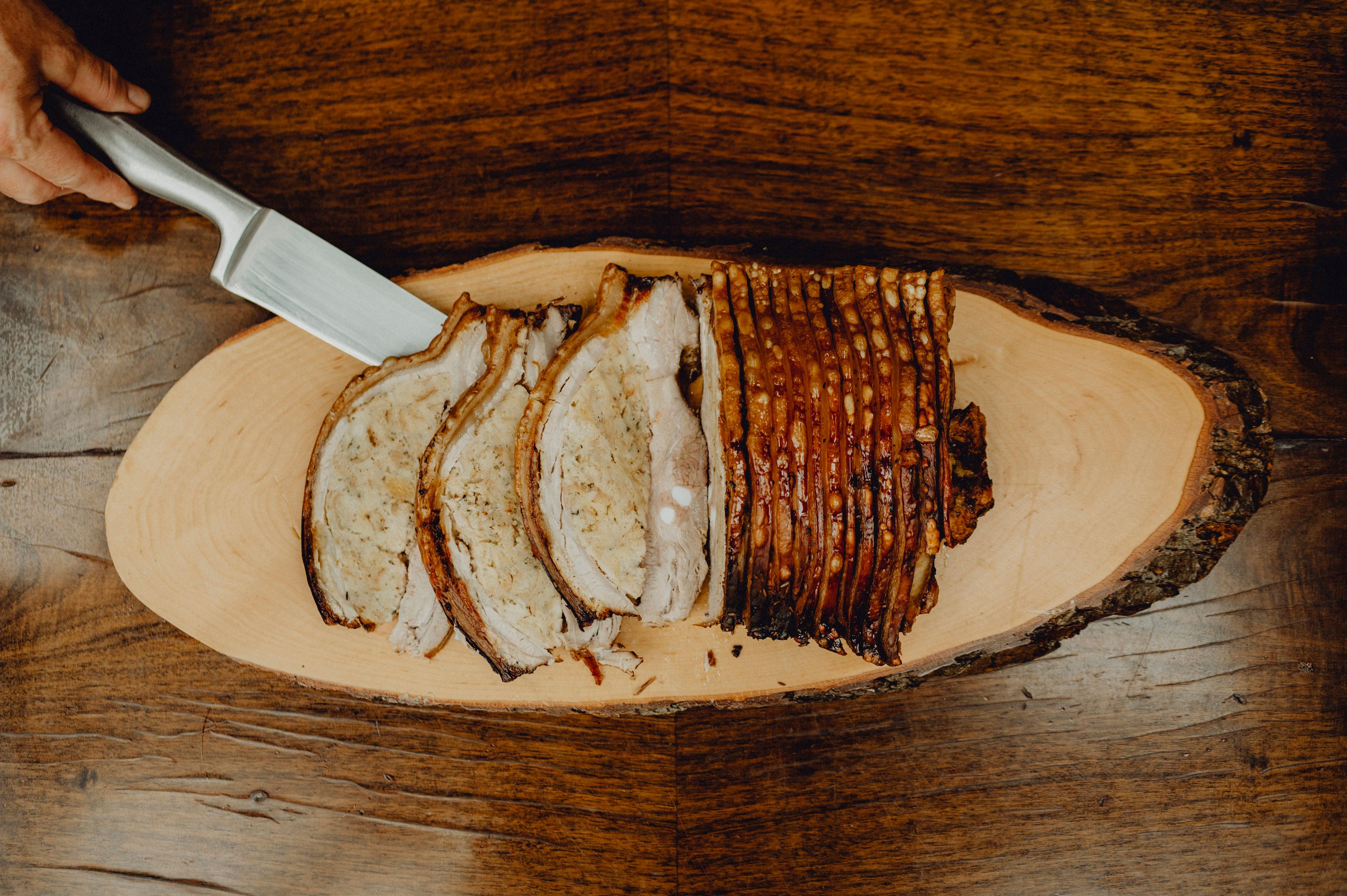 Sliced roast pork on a wooden board.