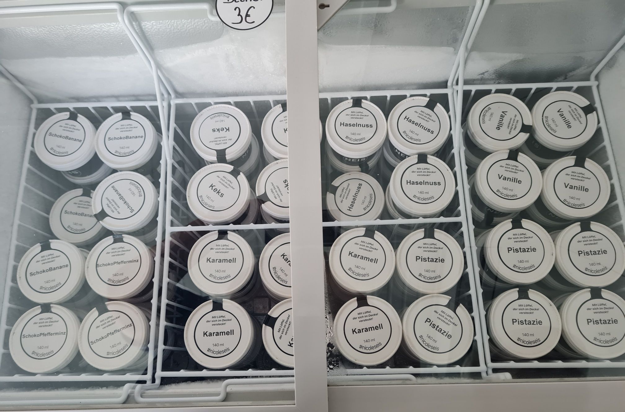 View into the ice cream freezer with many different types of ice cream