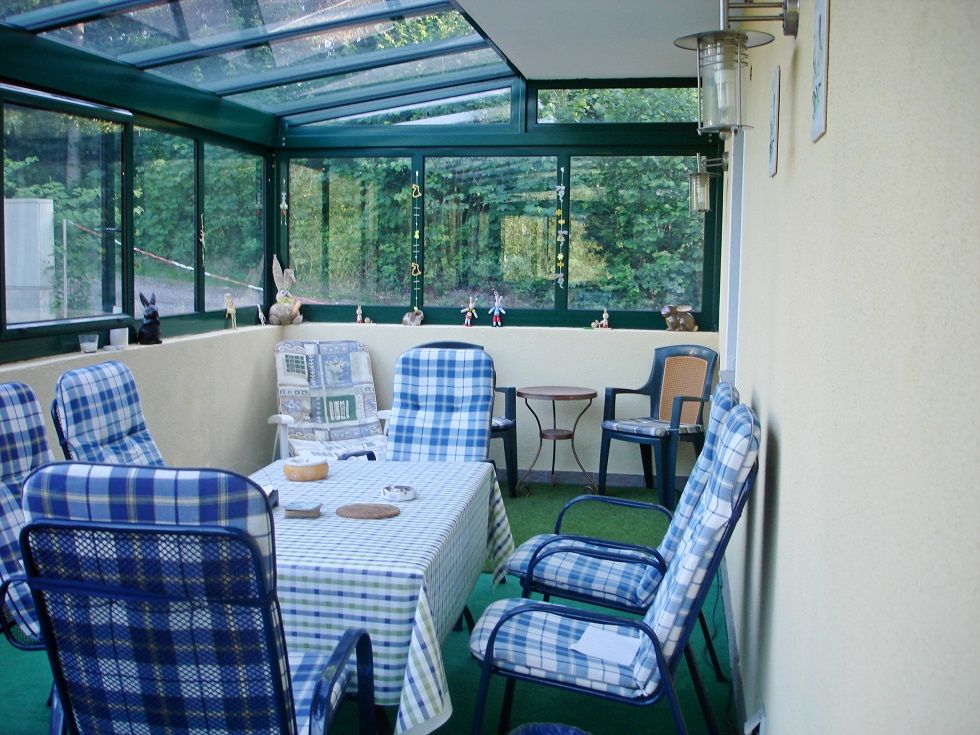 Winter garden with table and chairs, decorated with figures.
