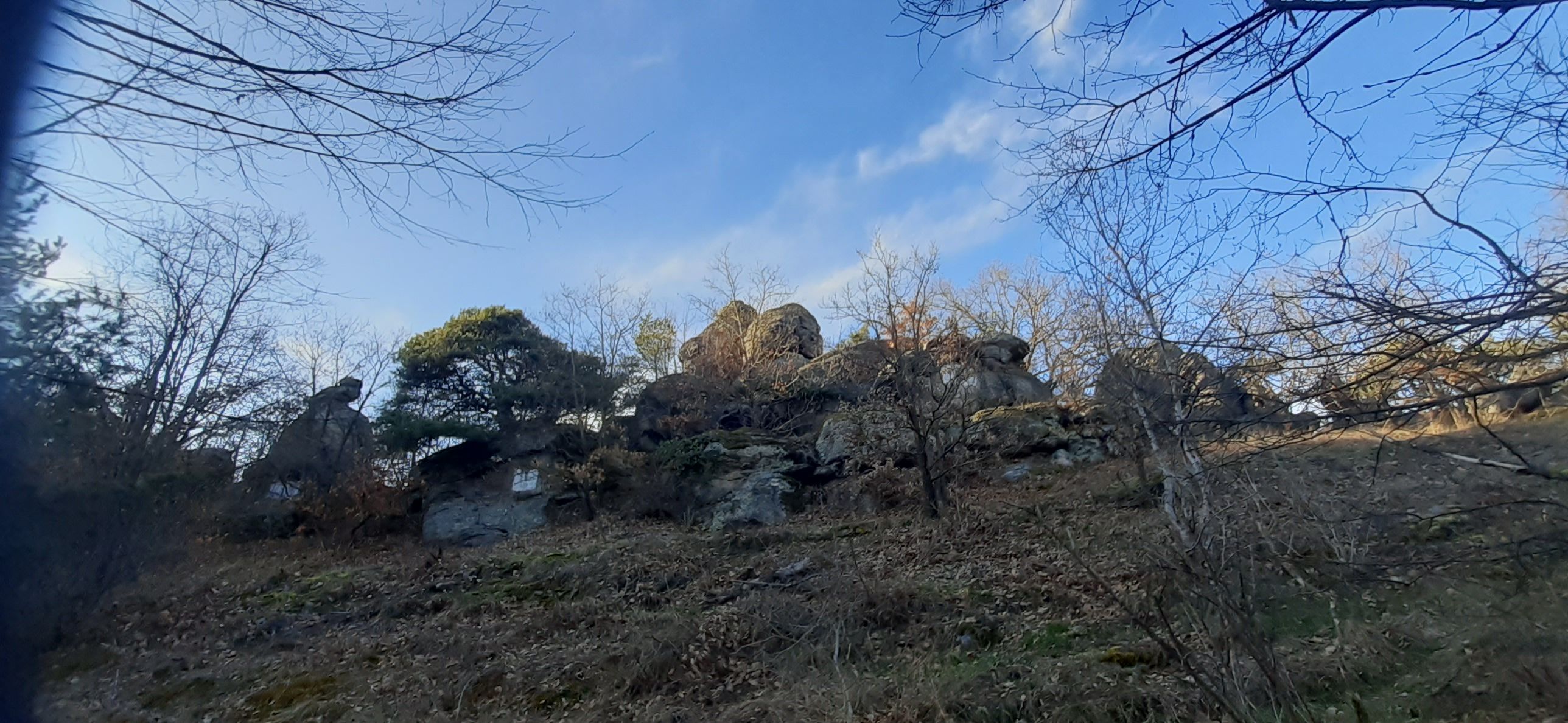 Rock formation with trees and blue sky in the background.