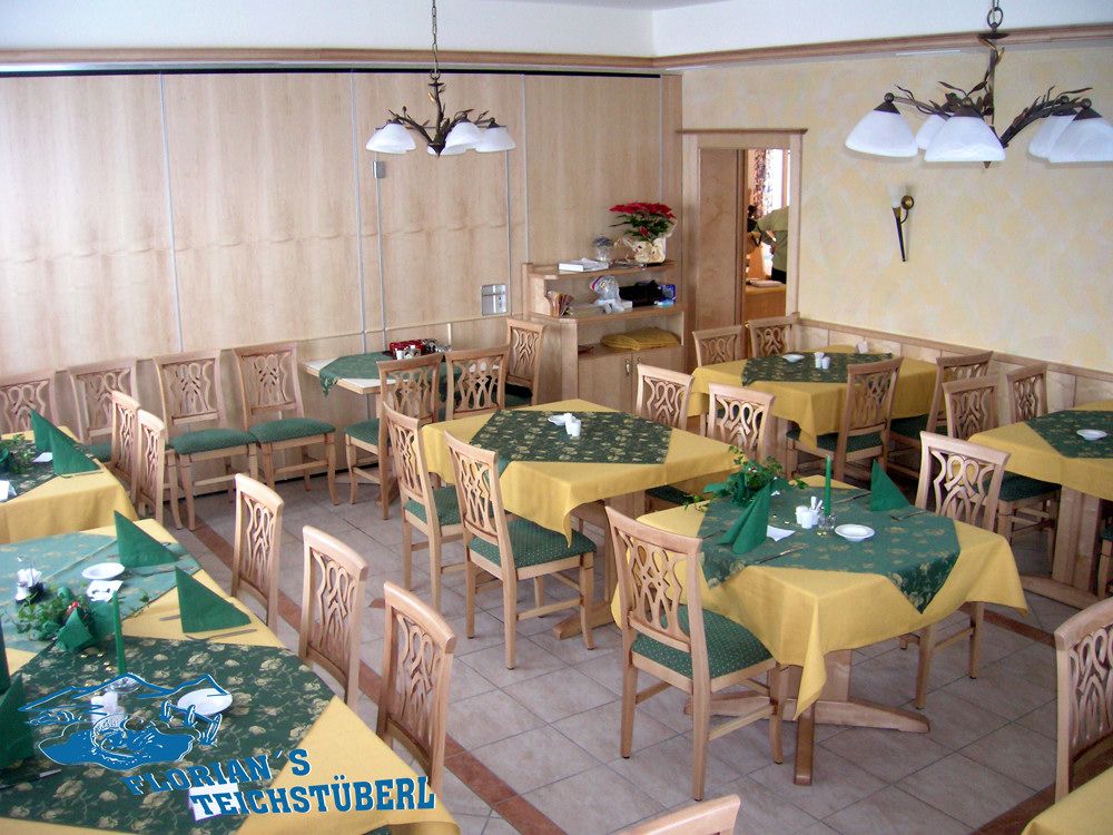 Interior view of a restaurant with wooden furniture and yellow-green tablecloths.