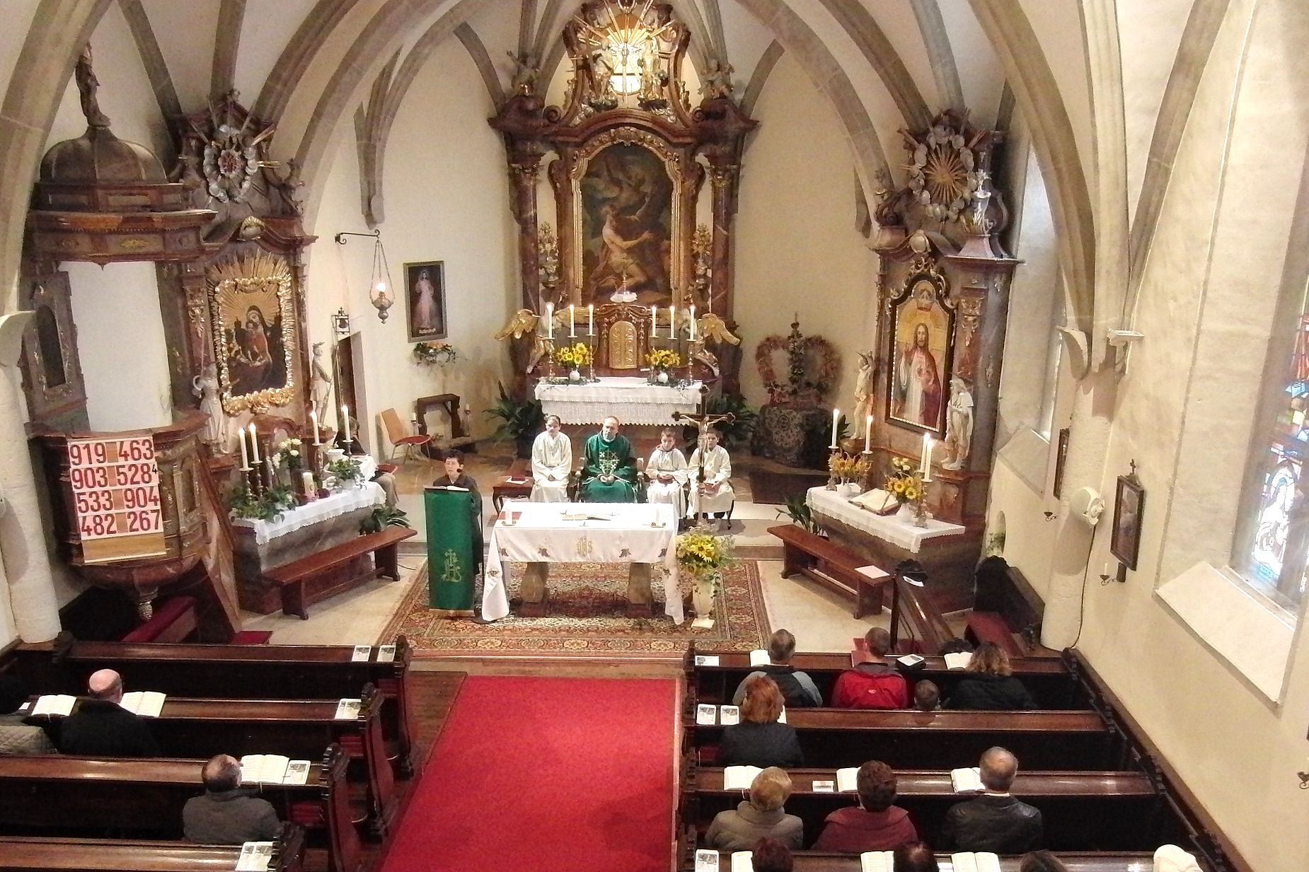 Interior view of a church during a mass with clergy and faithful.