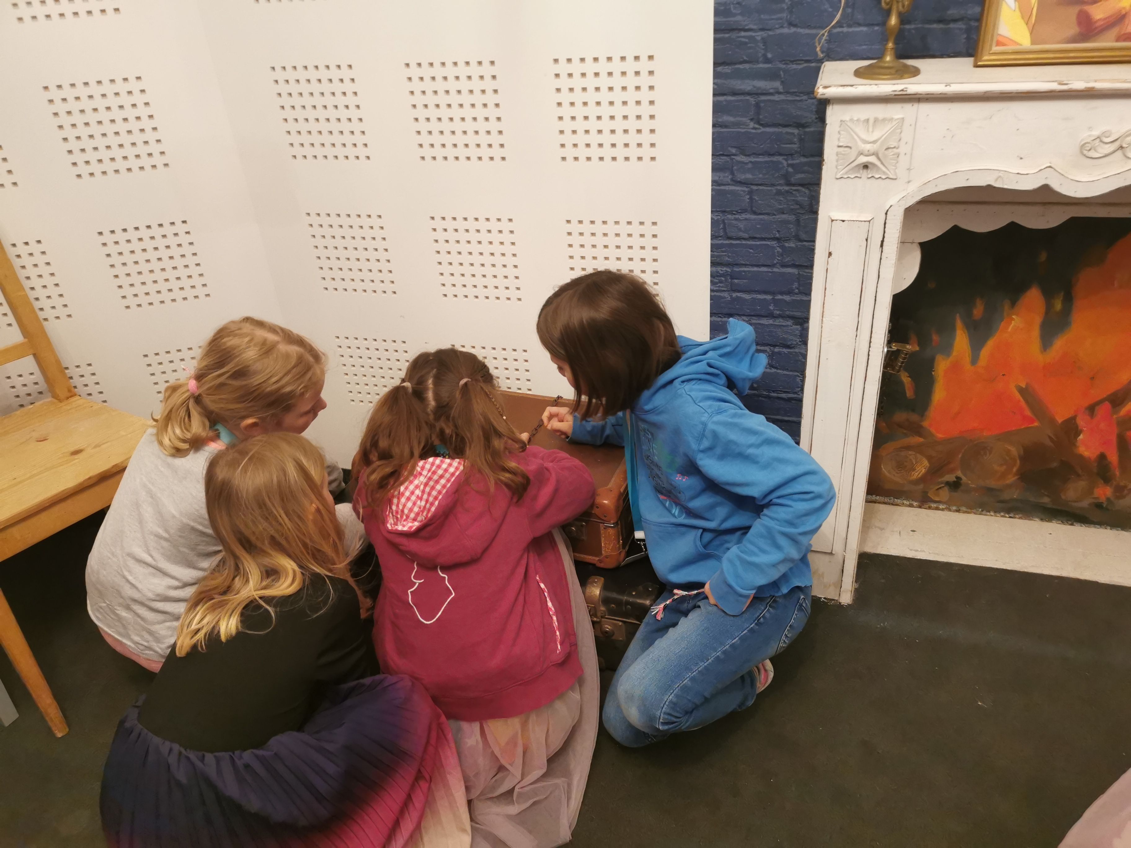 4 children sit on the floor and solve a puzzle 