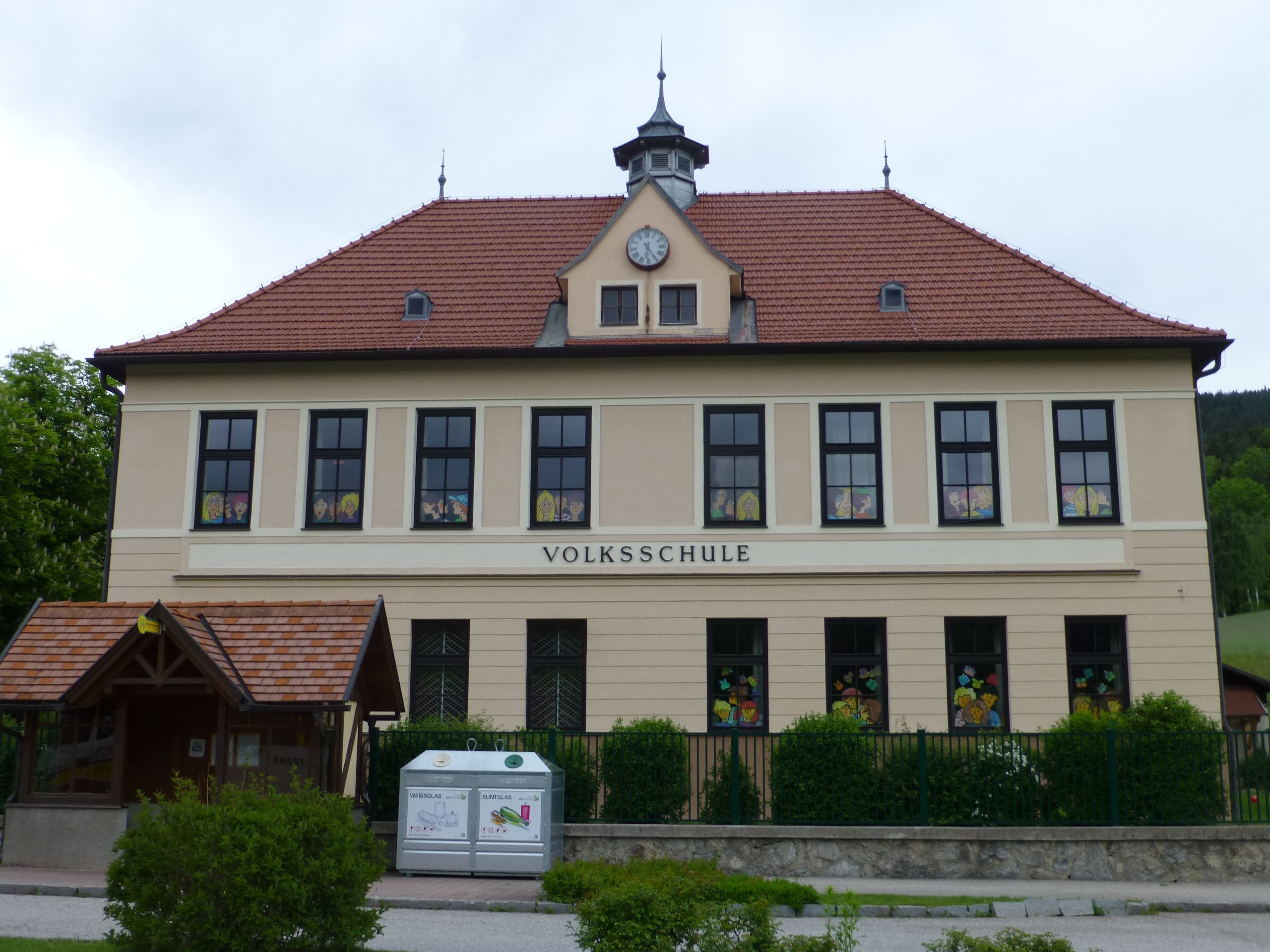 Front view of the Otterthal elementary school with red roof tiles and decorated windows.