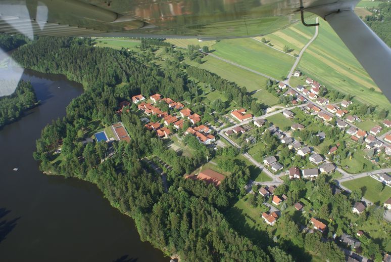 Aerial view of a golf course and a lake with adjoining housing estate.