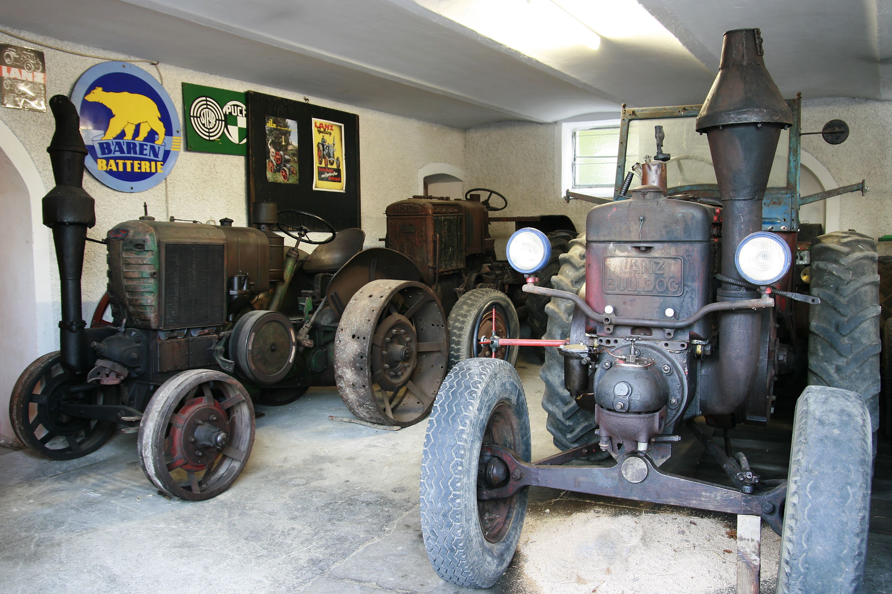 Old tractors on display in a museum.