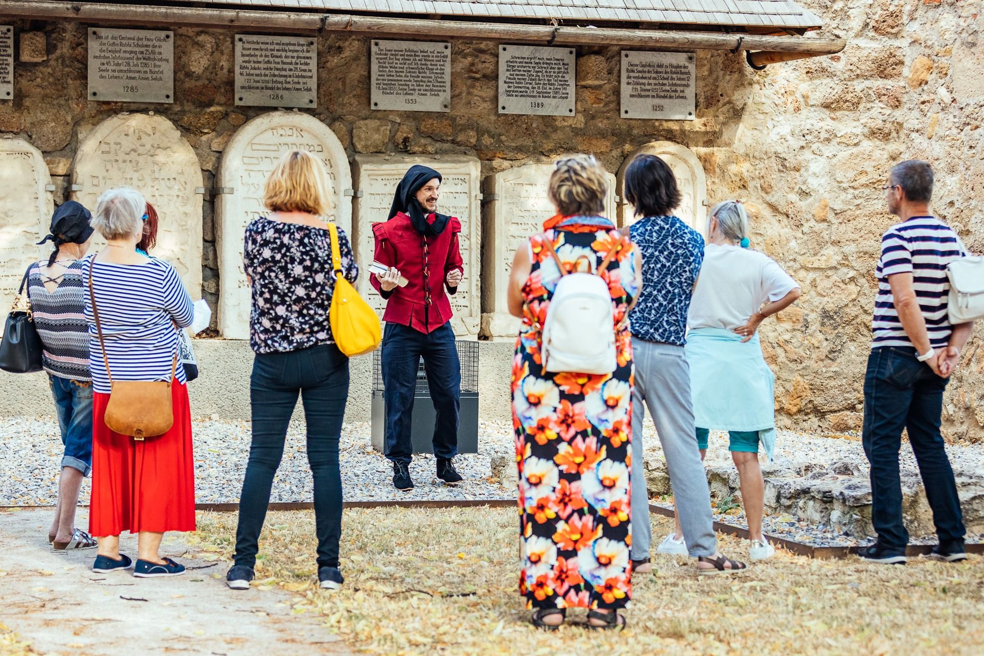 A man in a costume speaks to a group about the history of Wiener Neustadt