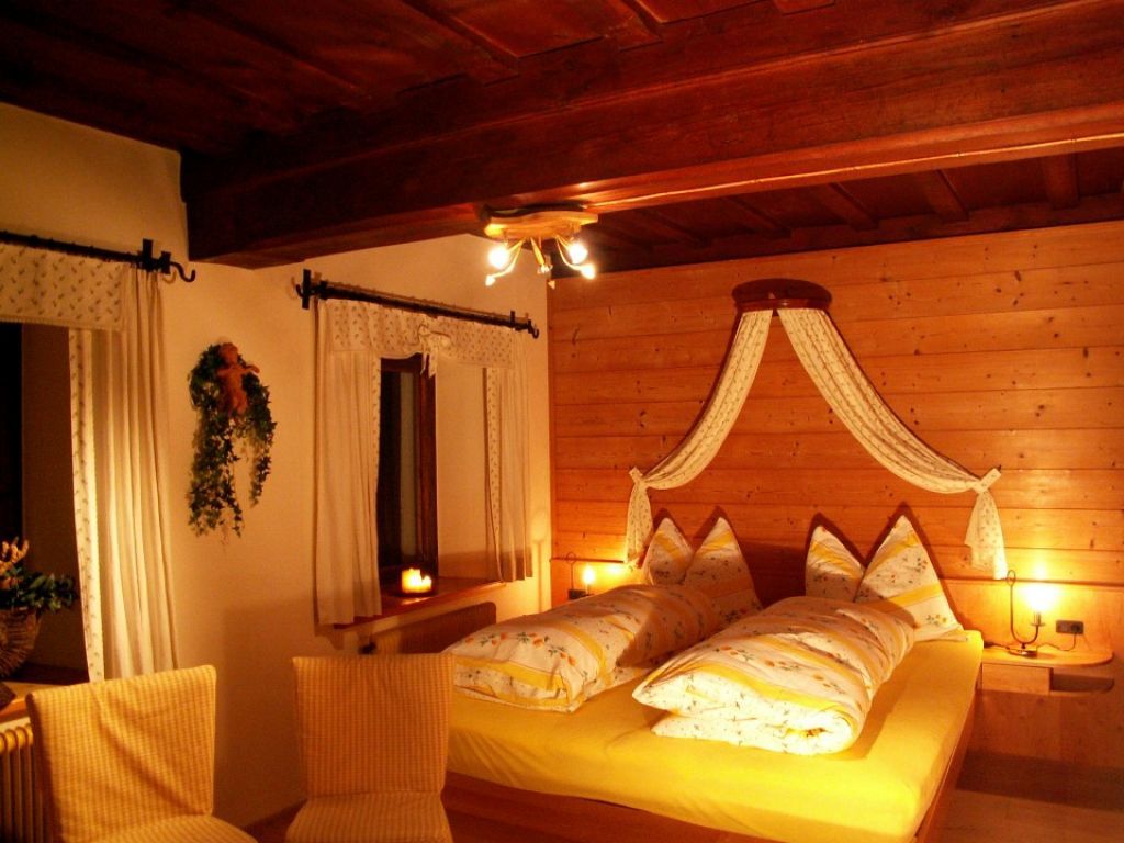 Cozy bedroom with wooden walls and yellow bed linen.