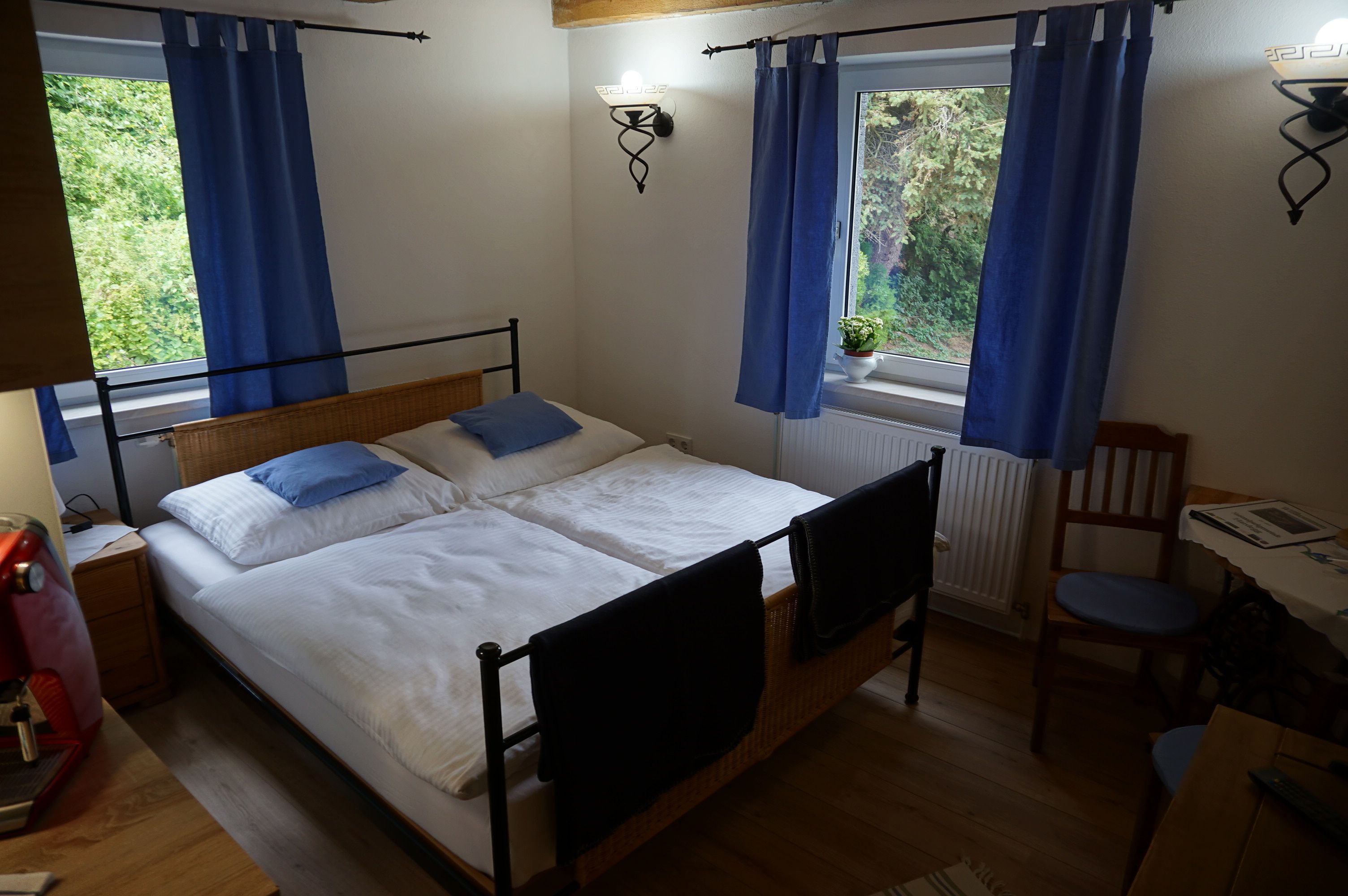Cozy bedroom with double bed, blue curtains and wooden furniture.