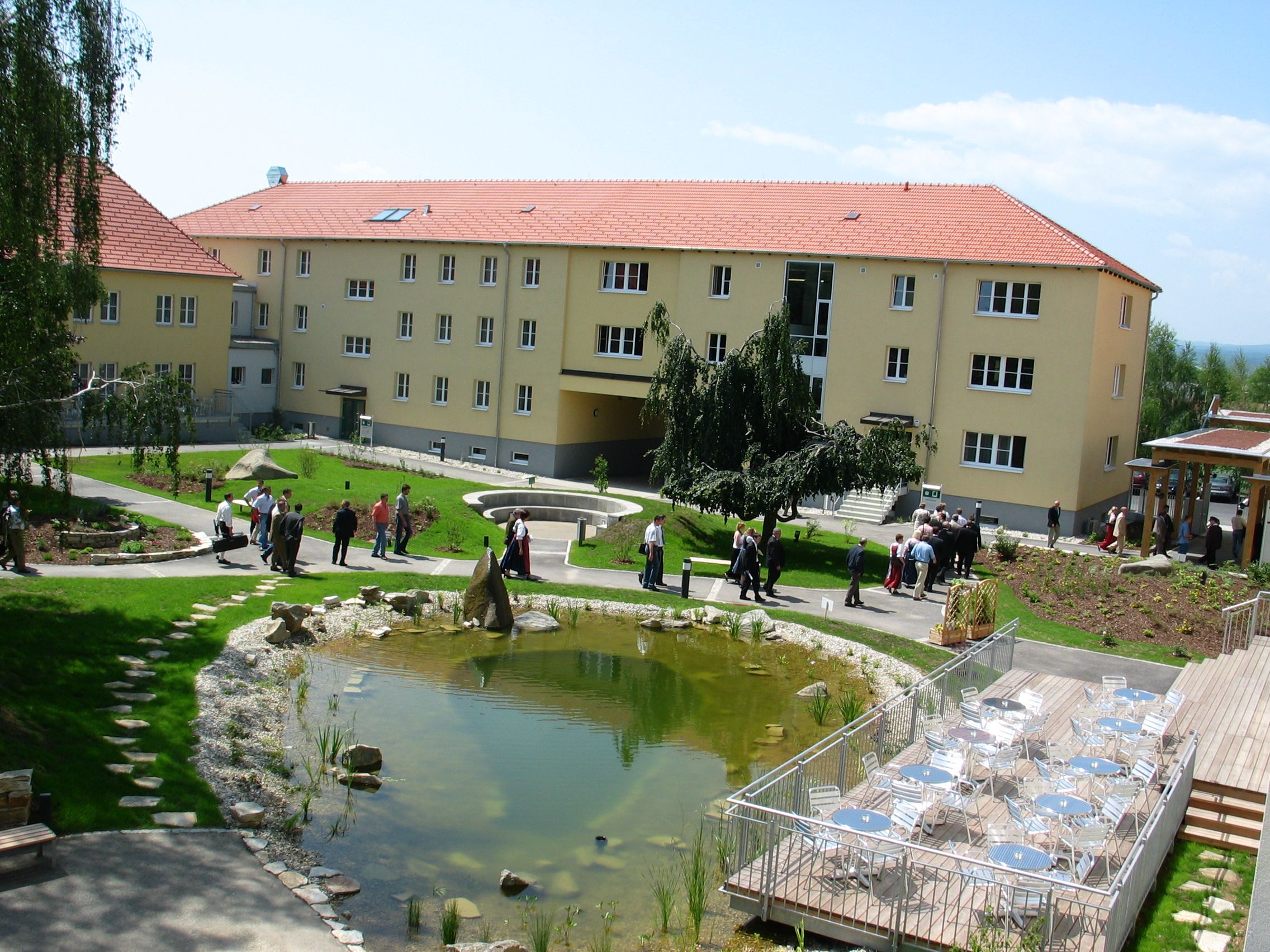 Inner courtyard with pond, seating area and people.