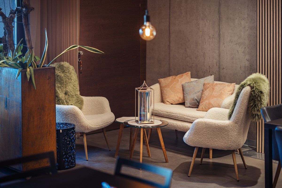 Comfortable seating area with sofa, armchairs and cushions.