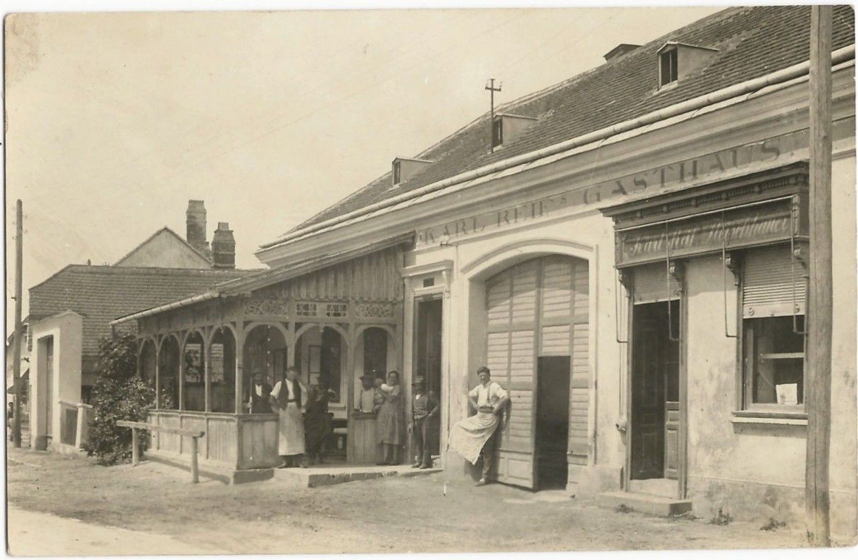 Historical photo of an inn with people in front of the entrance.