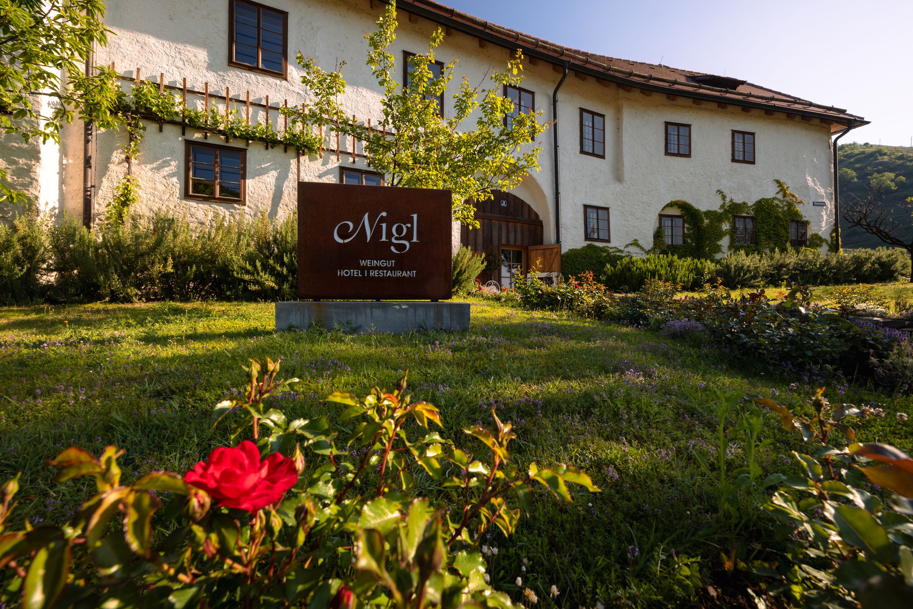 Exterior view of the Weinhotel Nigl with garden and sign.