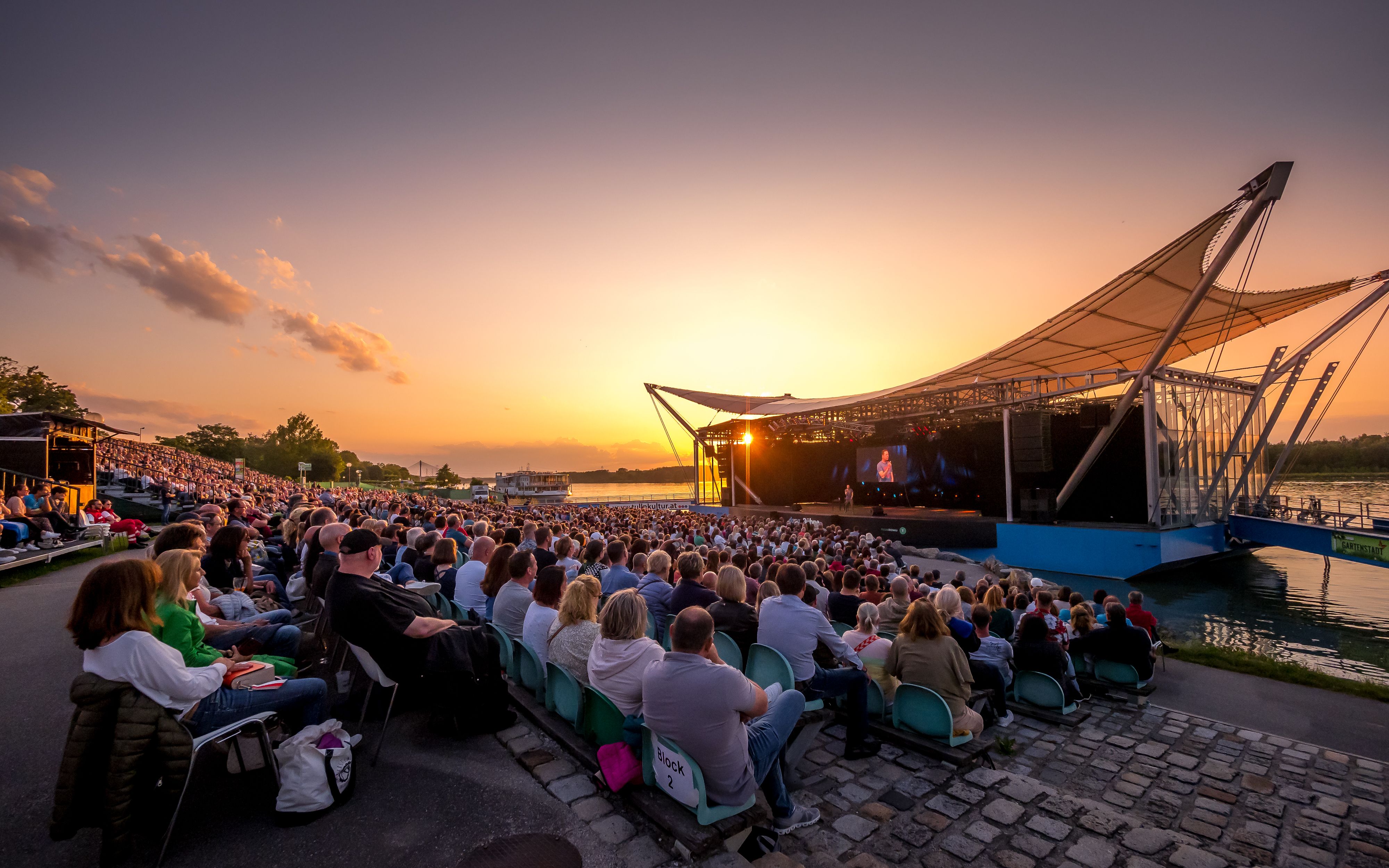 Open-air event on the Danube stage in Tulln at sunset.