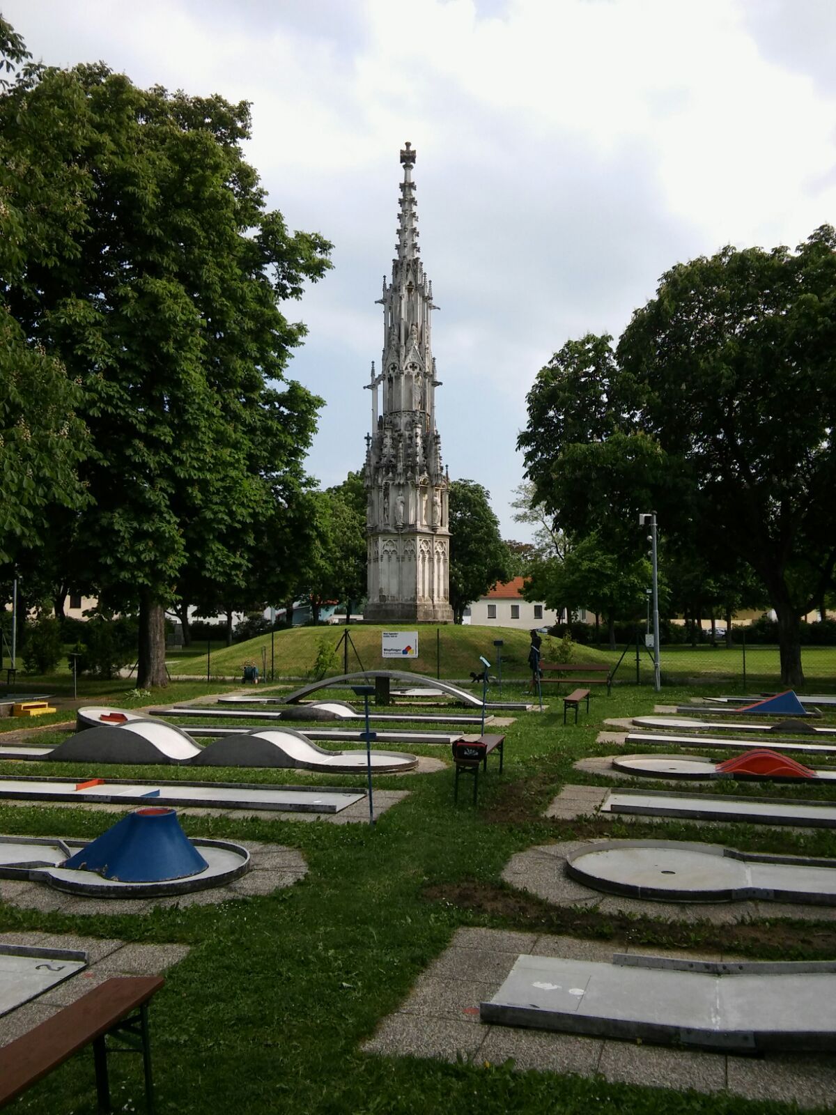 Minigolf course with Gothic monument in the background.