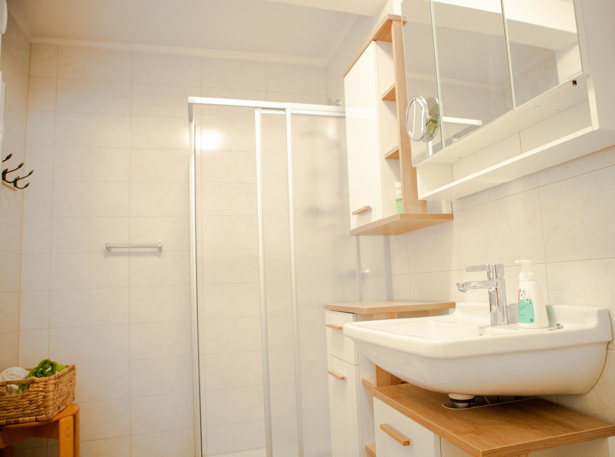 Modern bathroom with shower, washbasin and mirror.